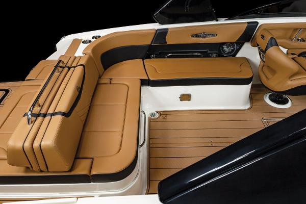 2024 Chaparral 28 Surf boat interior with tan leather seating and wood flooring.
