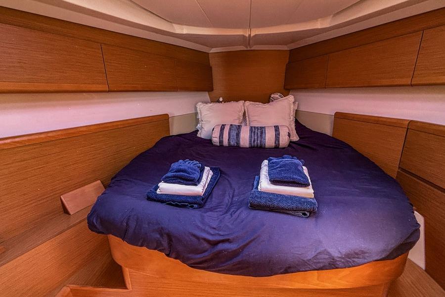 Cozy cabin interior of 2011 Jeanneau Sun Odyssey 44 with neatly arranged bedding.