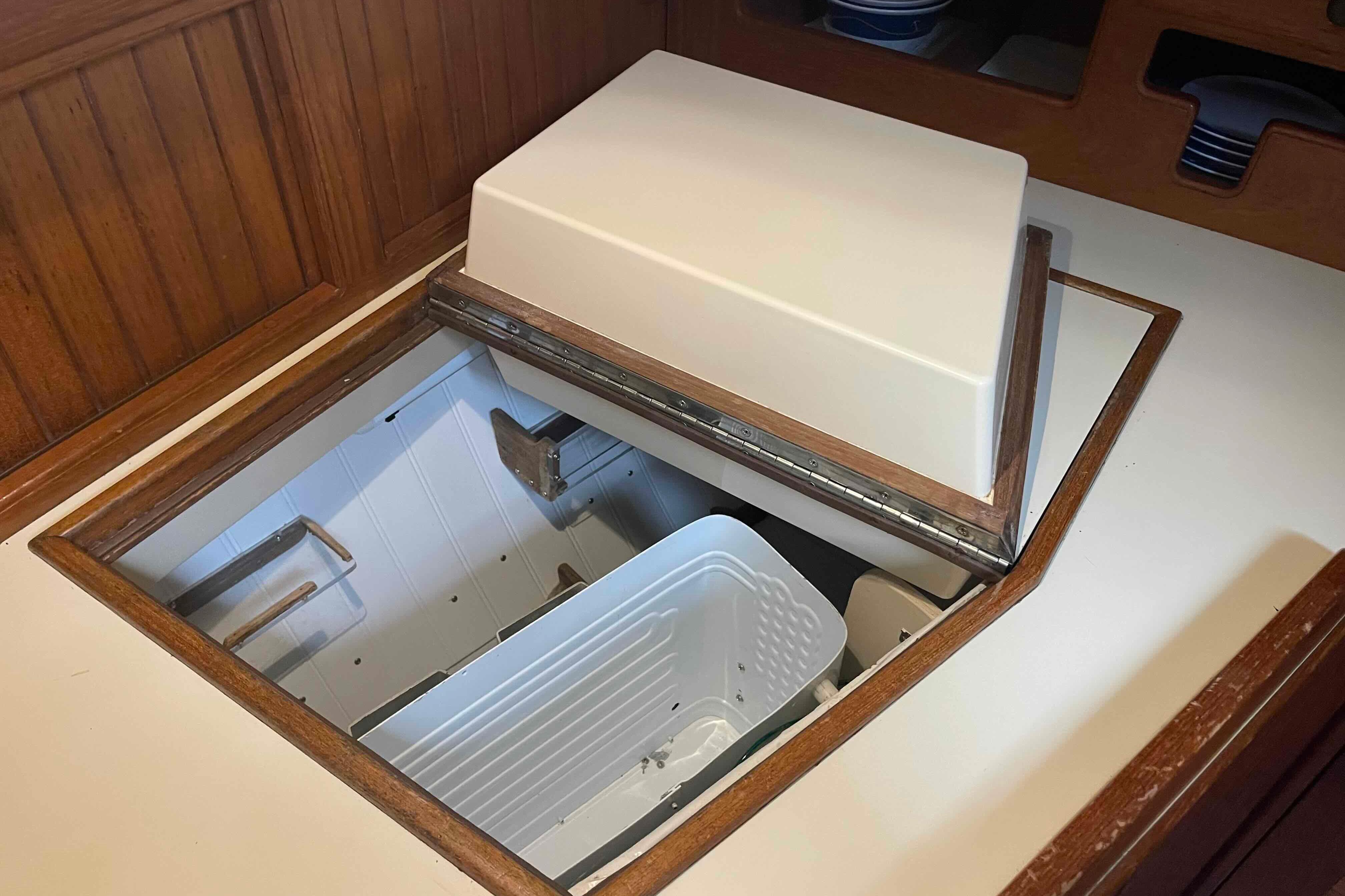 1998 Island Packet 40 yacht interior with open storage compartment in wooden cabinetry.