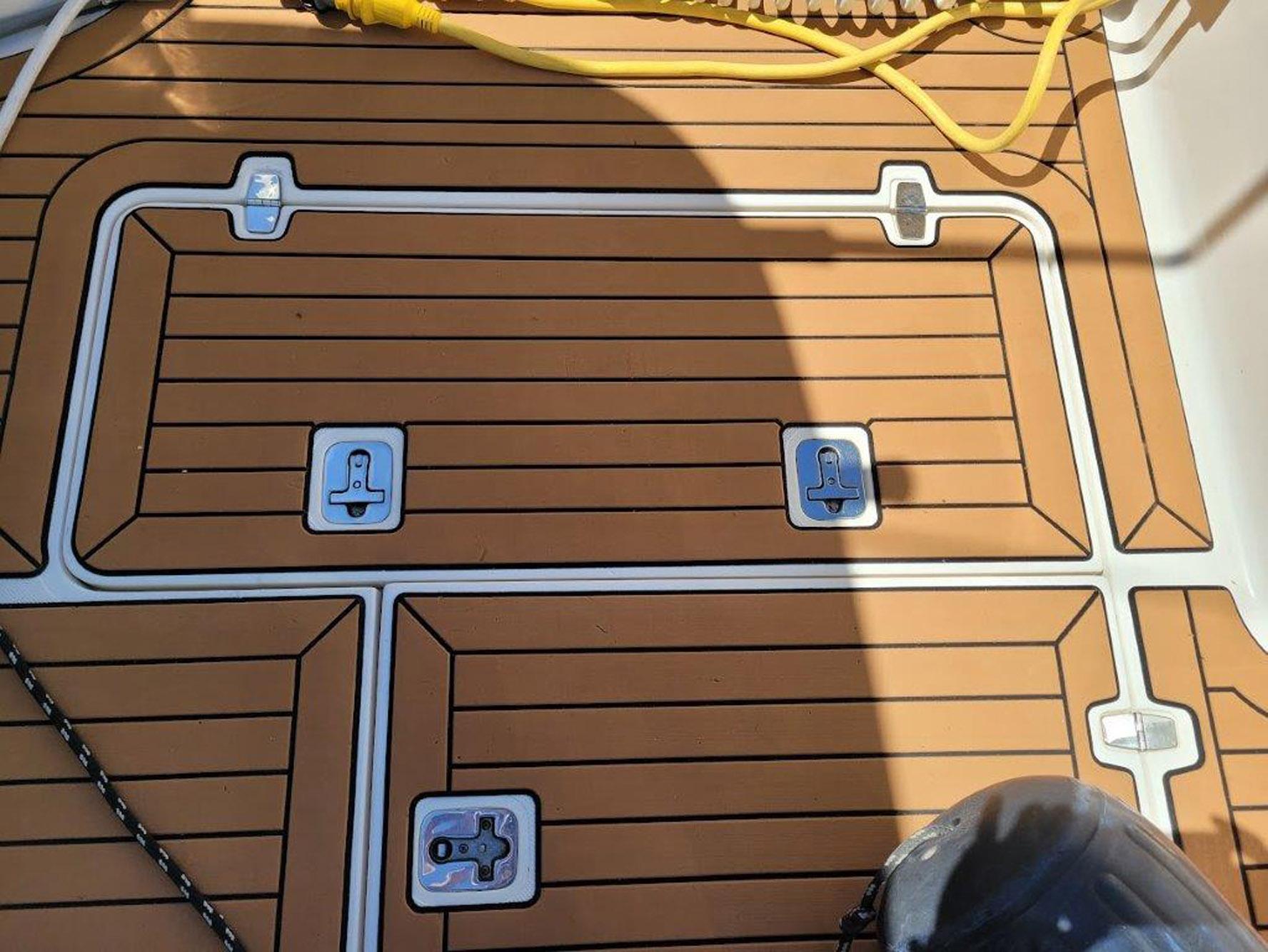 Deck of 2013 Pursuit 345 OS Offshore boat with teak flooring and metal fixtures.