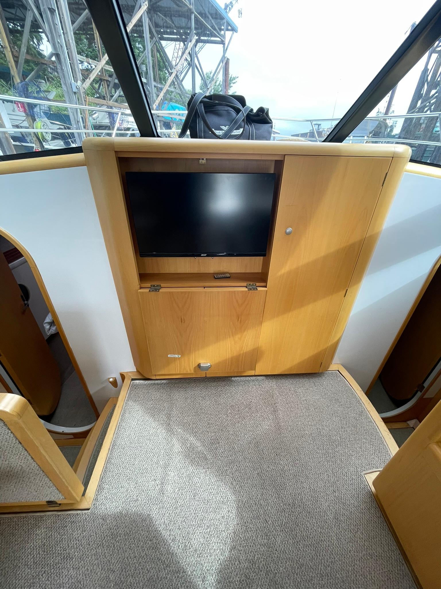 Interior of 1997 Roger Hill 11.2m Powercat with wooden cabinetry and mounted TV.