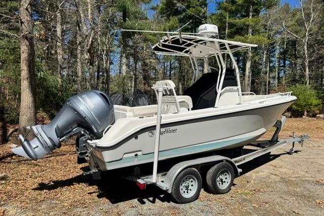 2021 Edgewater 208CC boat on trailer in wooded area.