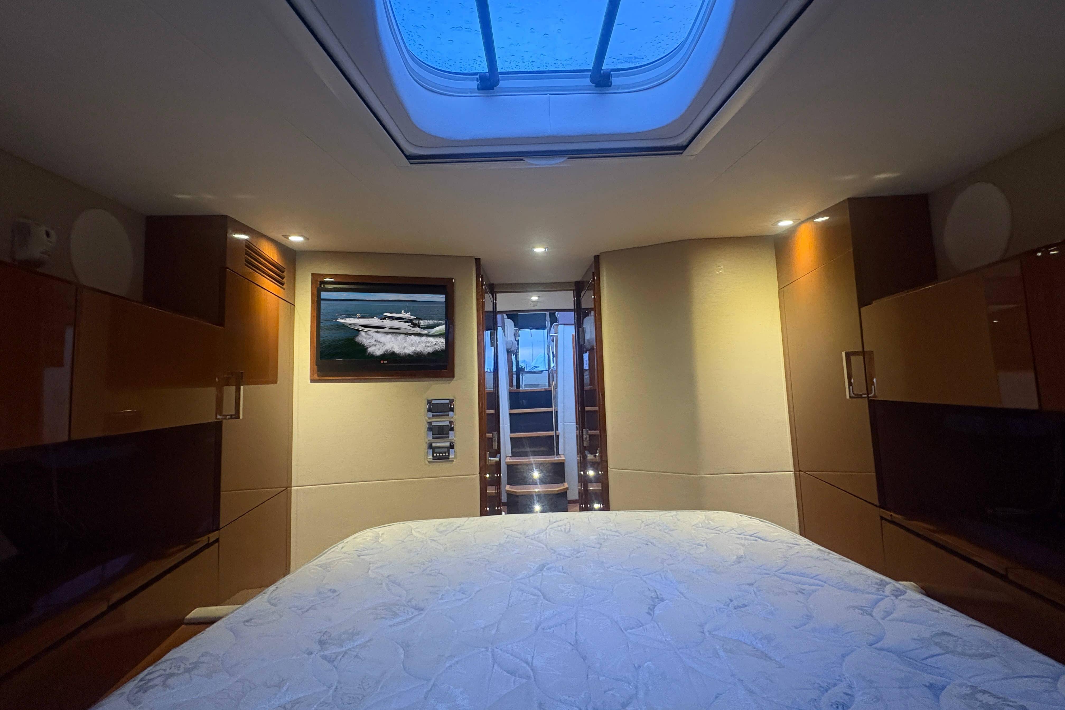 Luxurious 2015 Sea Ray 470 Sundancer cabin interior with skylight and elegant wood finishes.