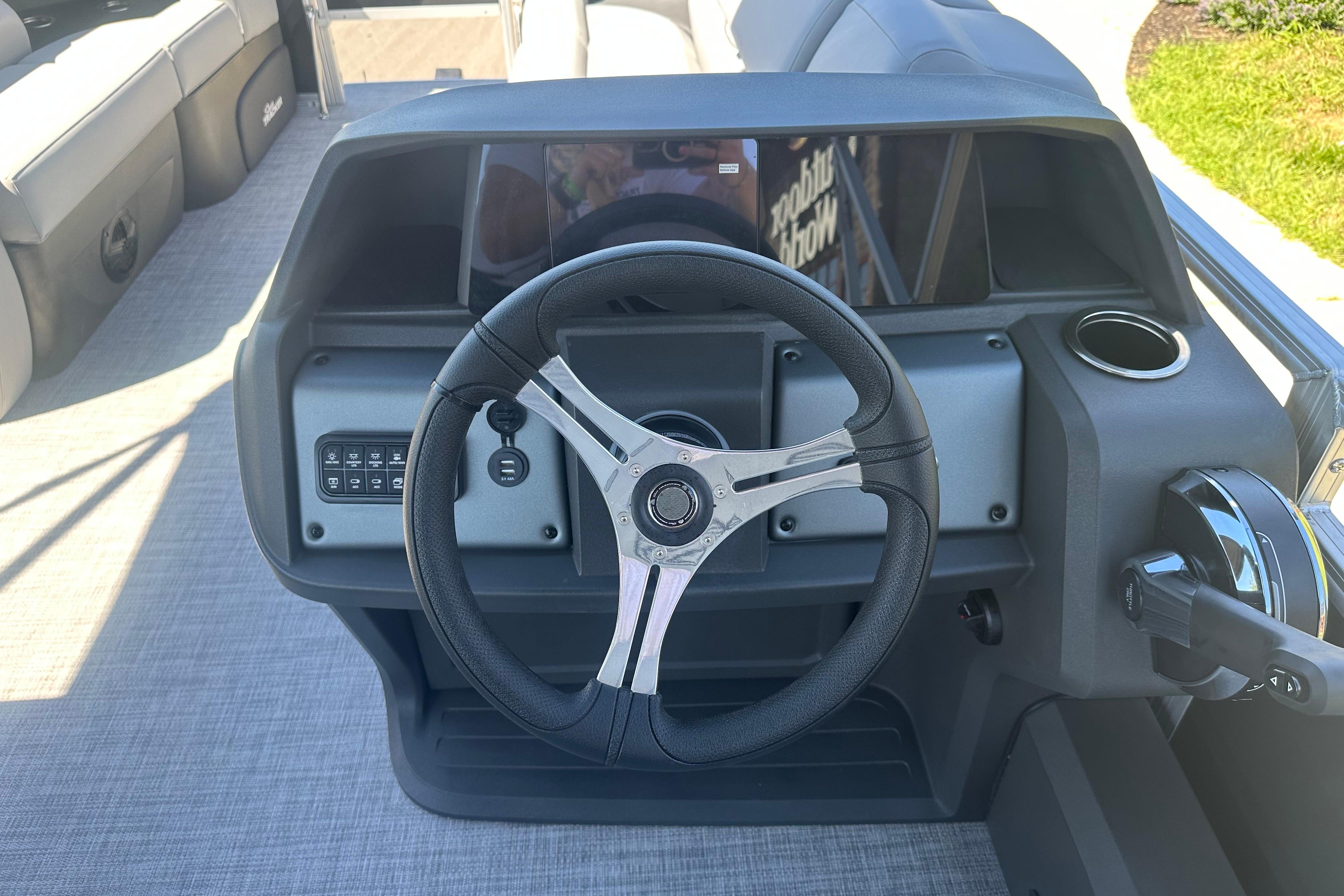 Steering console of 2026 Sun Tracker SportFish 22 DLX pontoon boat, featuring modern controls.