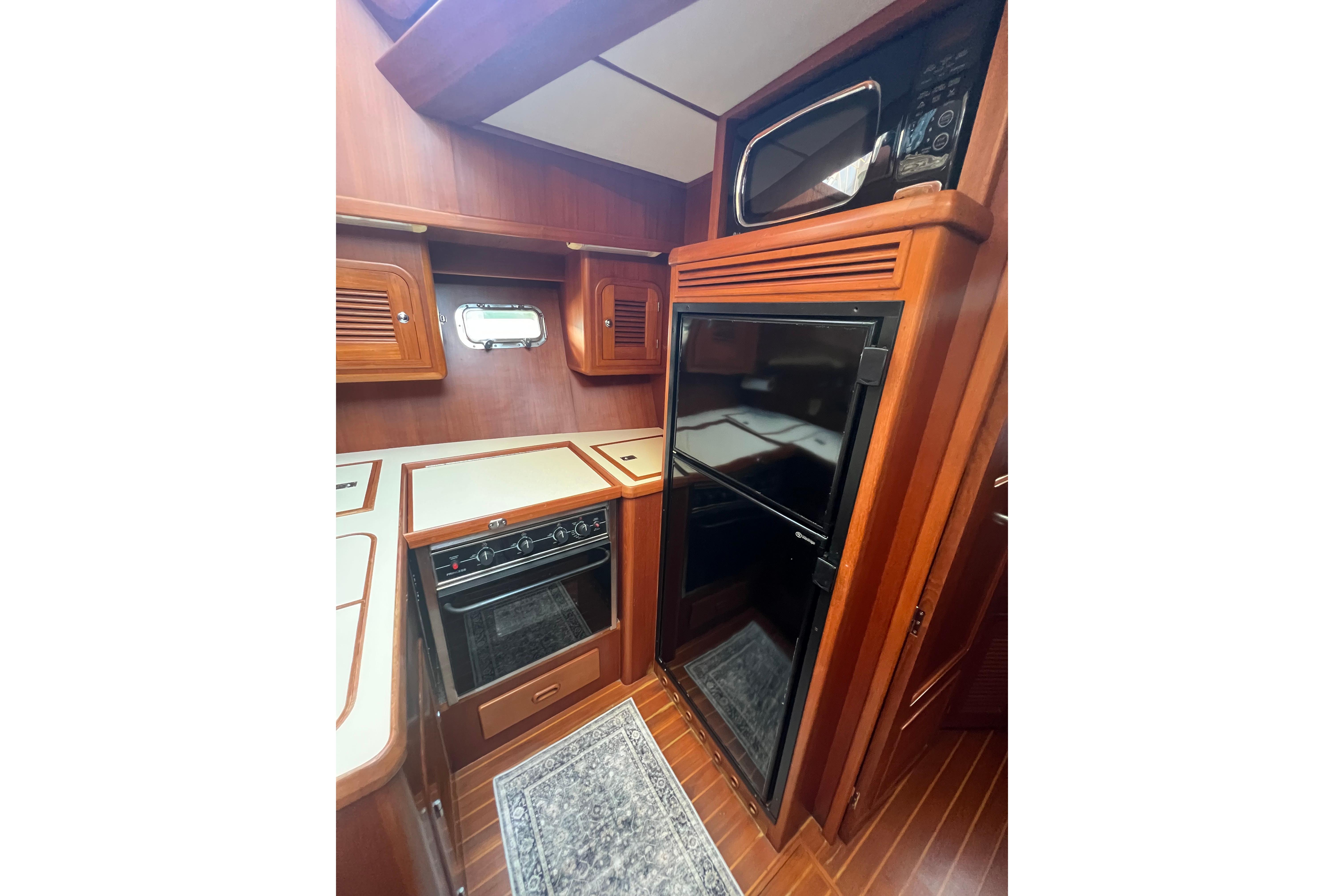 Interior of 2007 Heritage East 36 Sundeck Trawler with wood cabinetry and modern appliances.