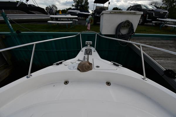 2003 Sea Ray 460 Sundancer boat bow at dock with railing and equipment.