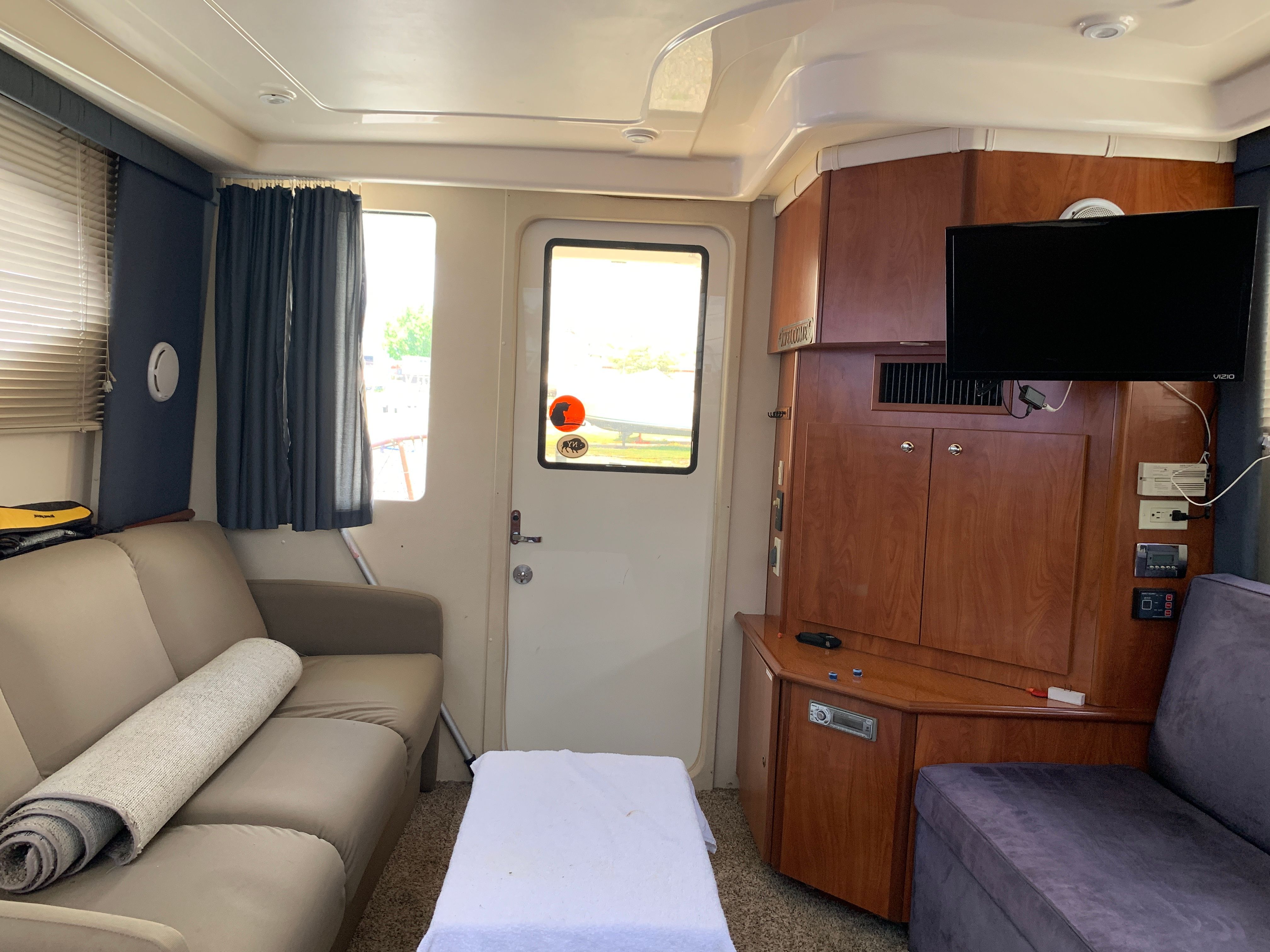 Interior of a Silverton 33 Convertible with sofa, TV, and wooden cabinetry.
