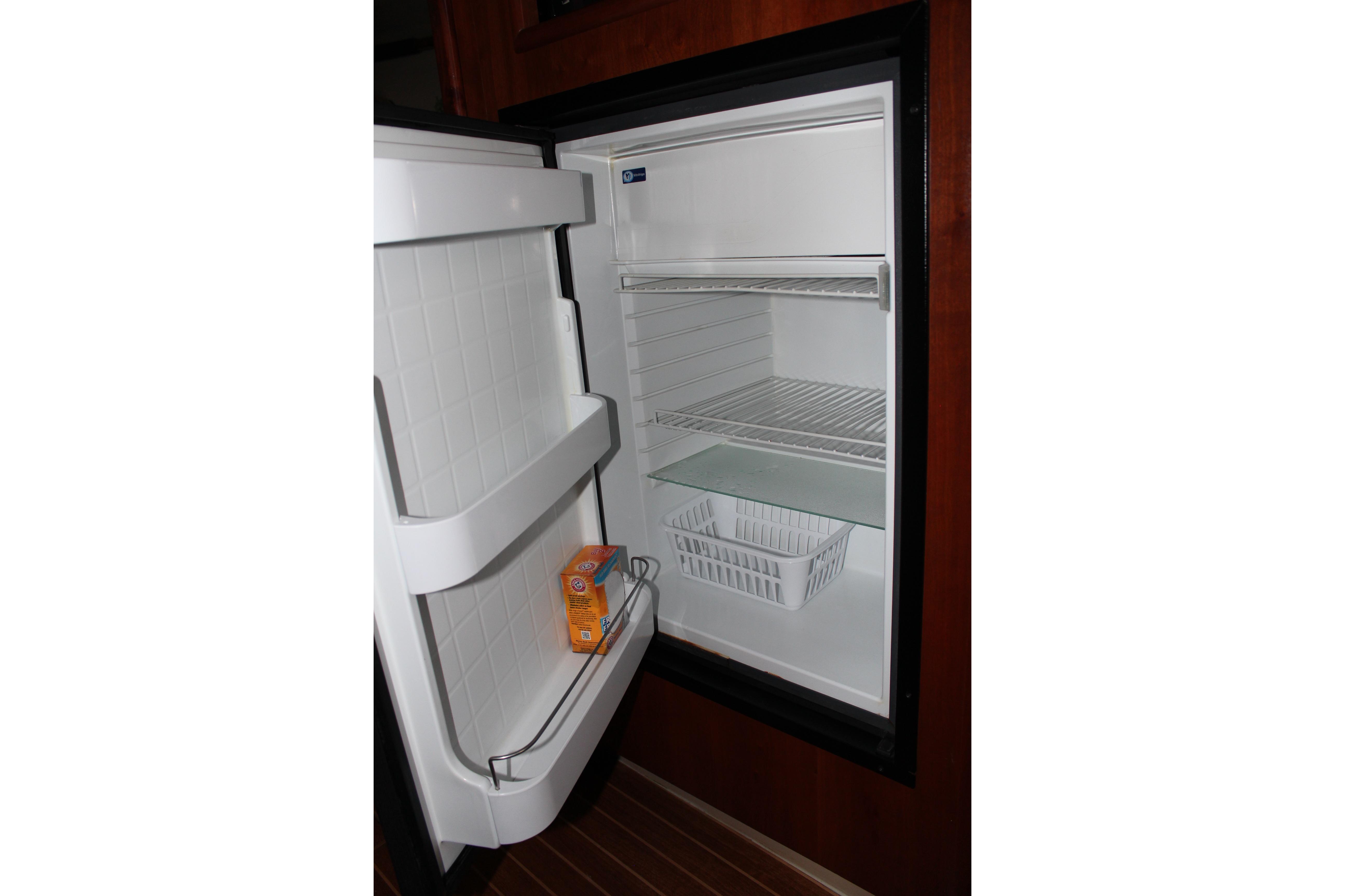 Open refrigerator inside 2005 Rampage 38 Express boat, featuring shelves and a door compartment.