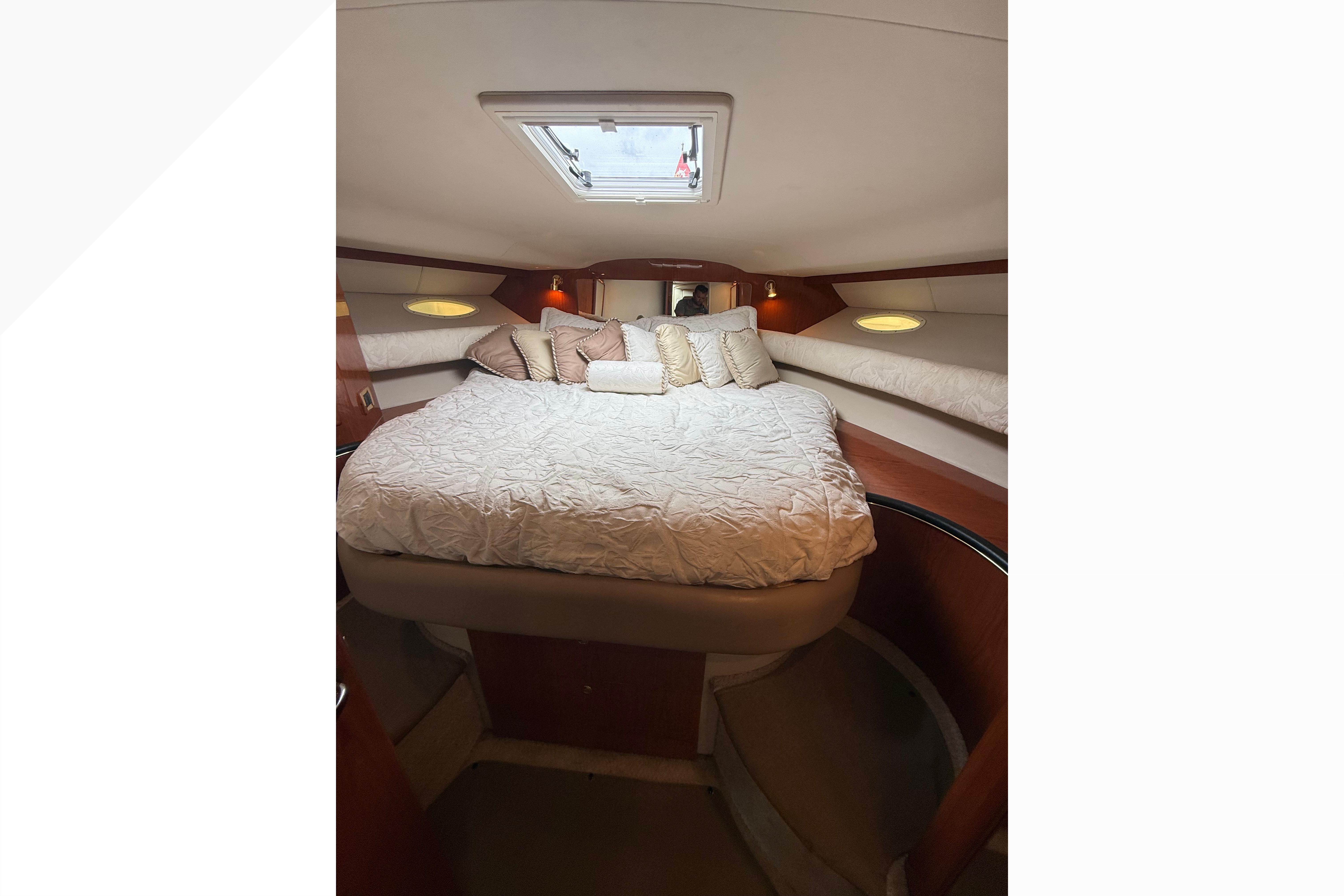 Luxurious cabin interior of 1998 Sea Ray Sundancer 400 yacht with cozy bedding.