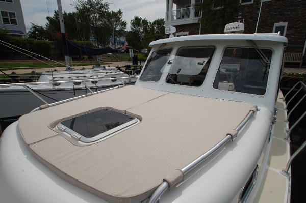 A 2005 Fox Island Thirty Sedan Cruiser docked. The boat features a beige deck.