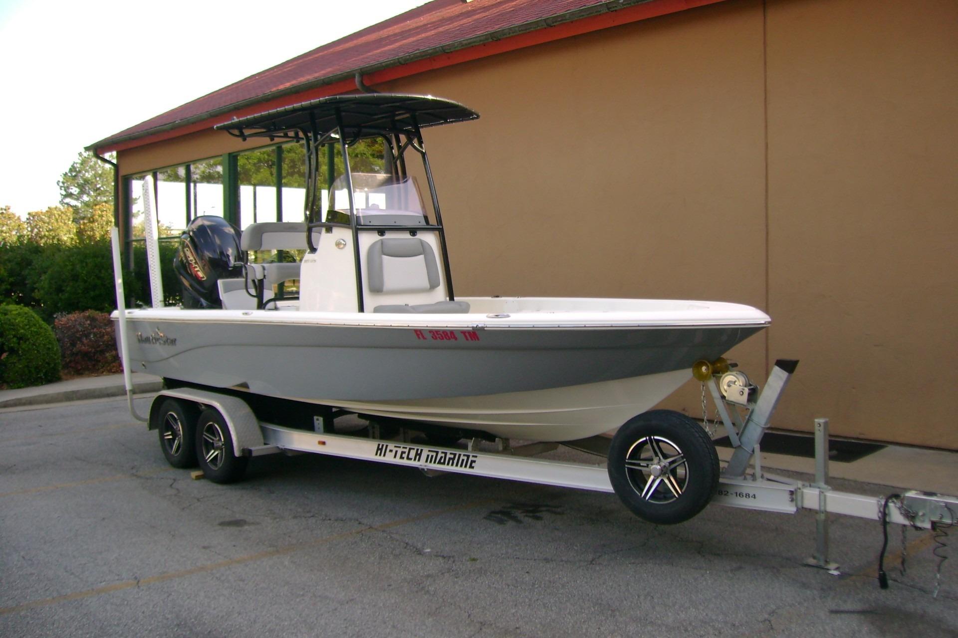 2022 NauticStar 227 XTS boat on trailer, parked outdoors near a building.