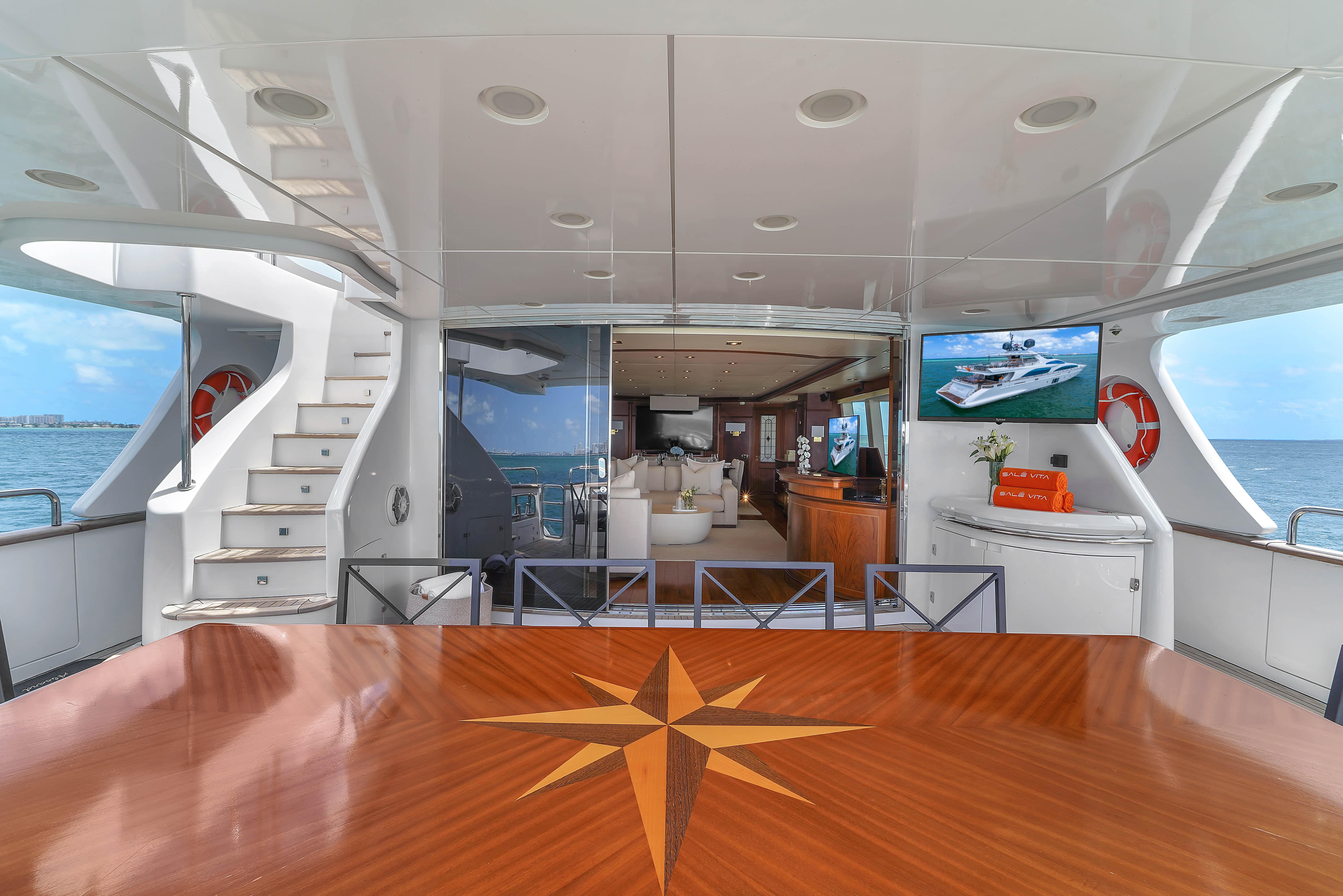 Luxurious 2012 Azimut Grande 105 yacht interior with elegant wood table and ocean view.