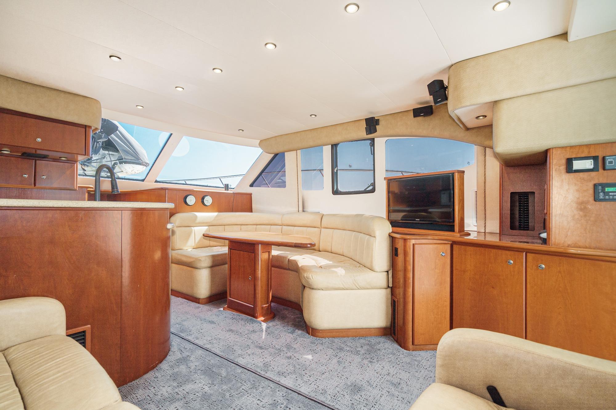 Luxurious interior of a 2007 Silverton Convertible yacht with plush seating and wooden cabinetry.