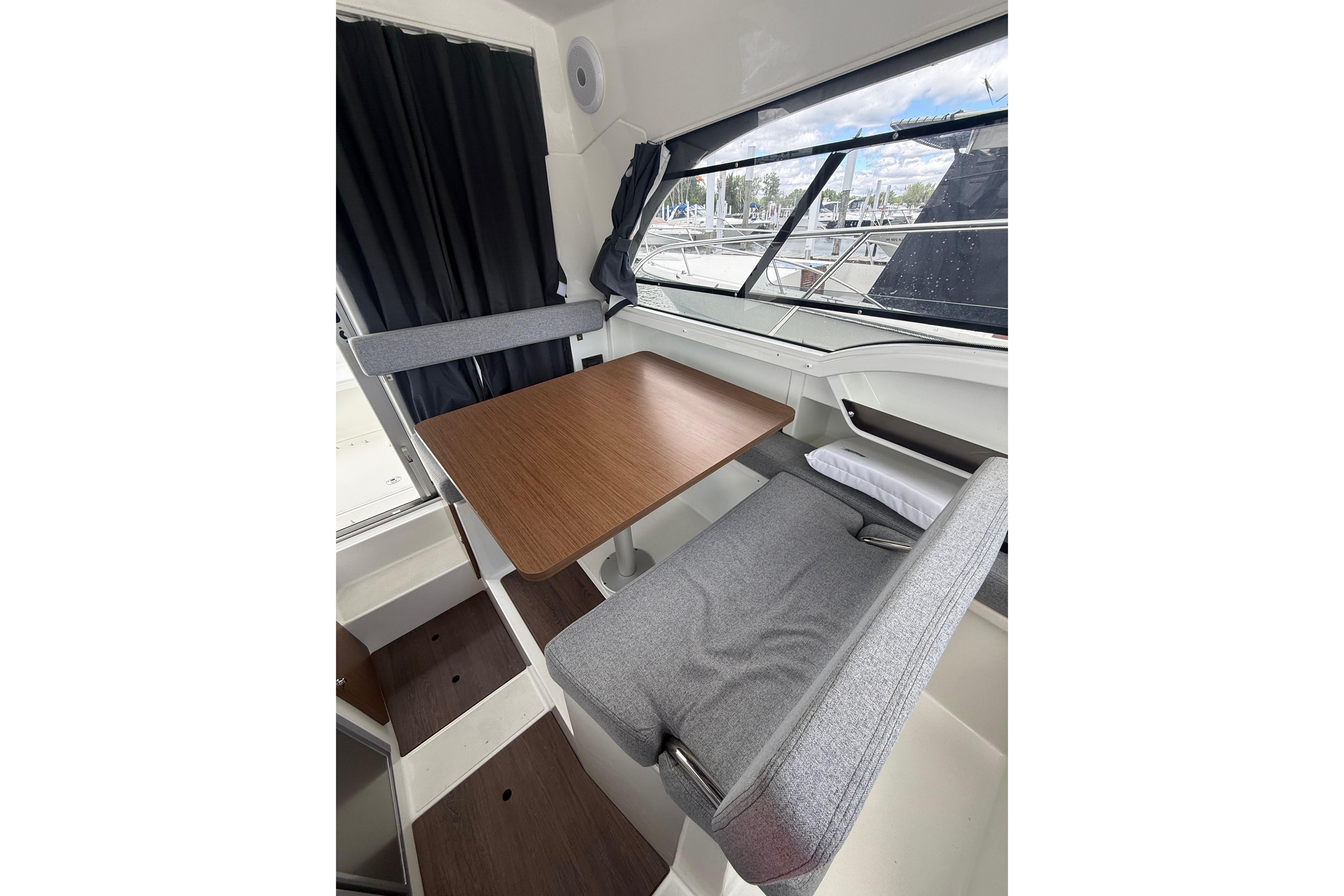 Interior of 2019 Beneteau Antares 23 boat with dining area and window view.