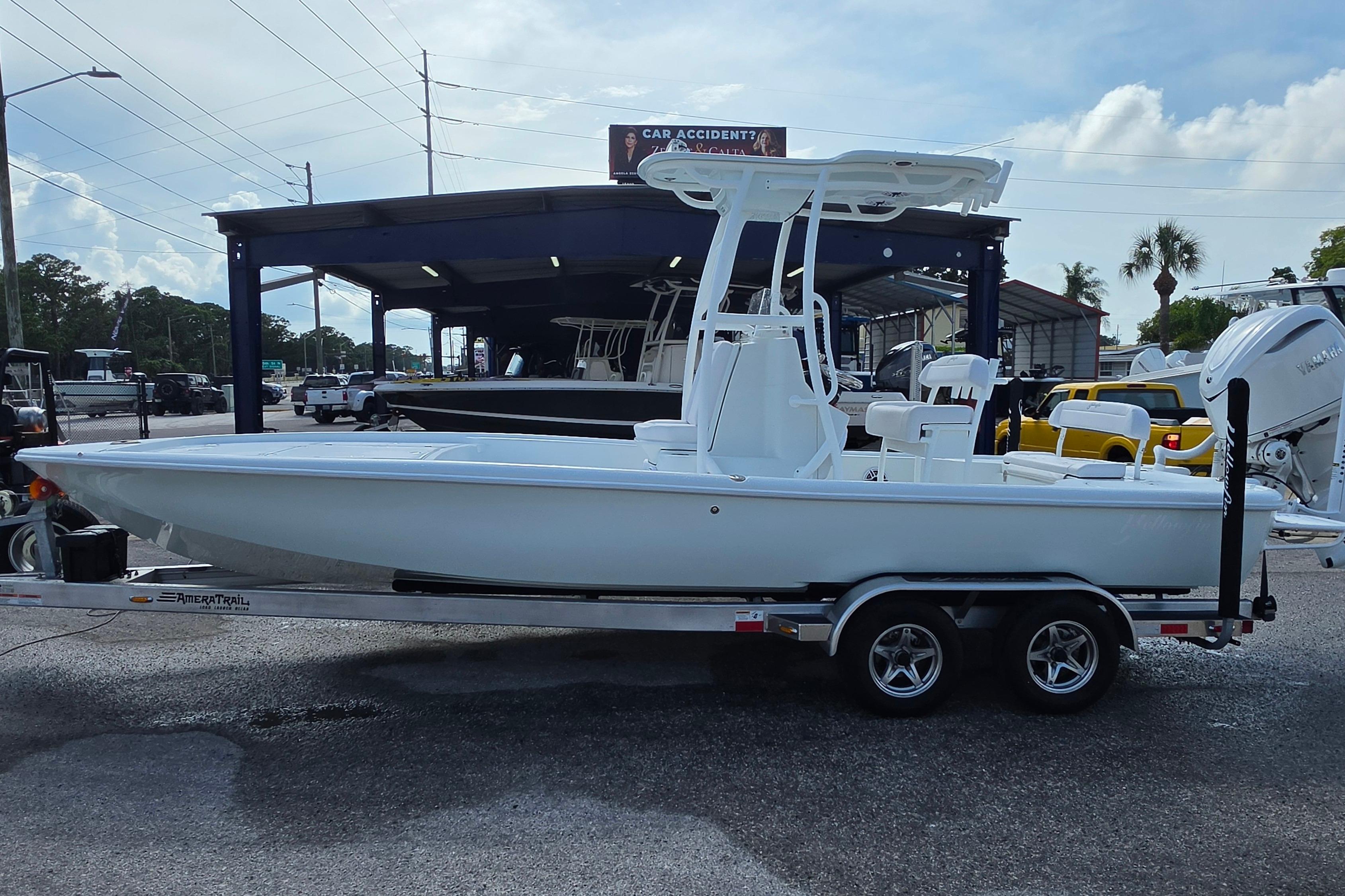 2026 Yellowfin 24 Bay CE boat on trailer, parked outdoors under a cloudy sky.