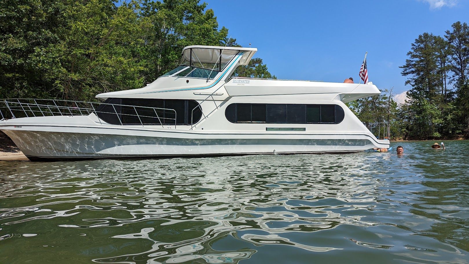 1996 Motor Yacht Blue Water on a serene lake.