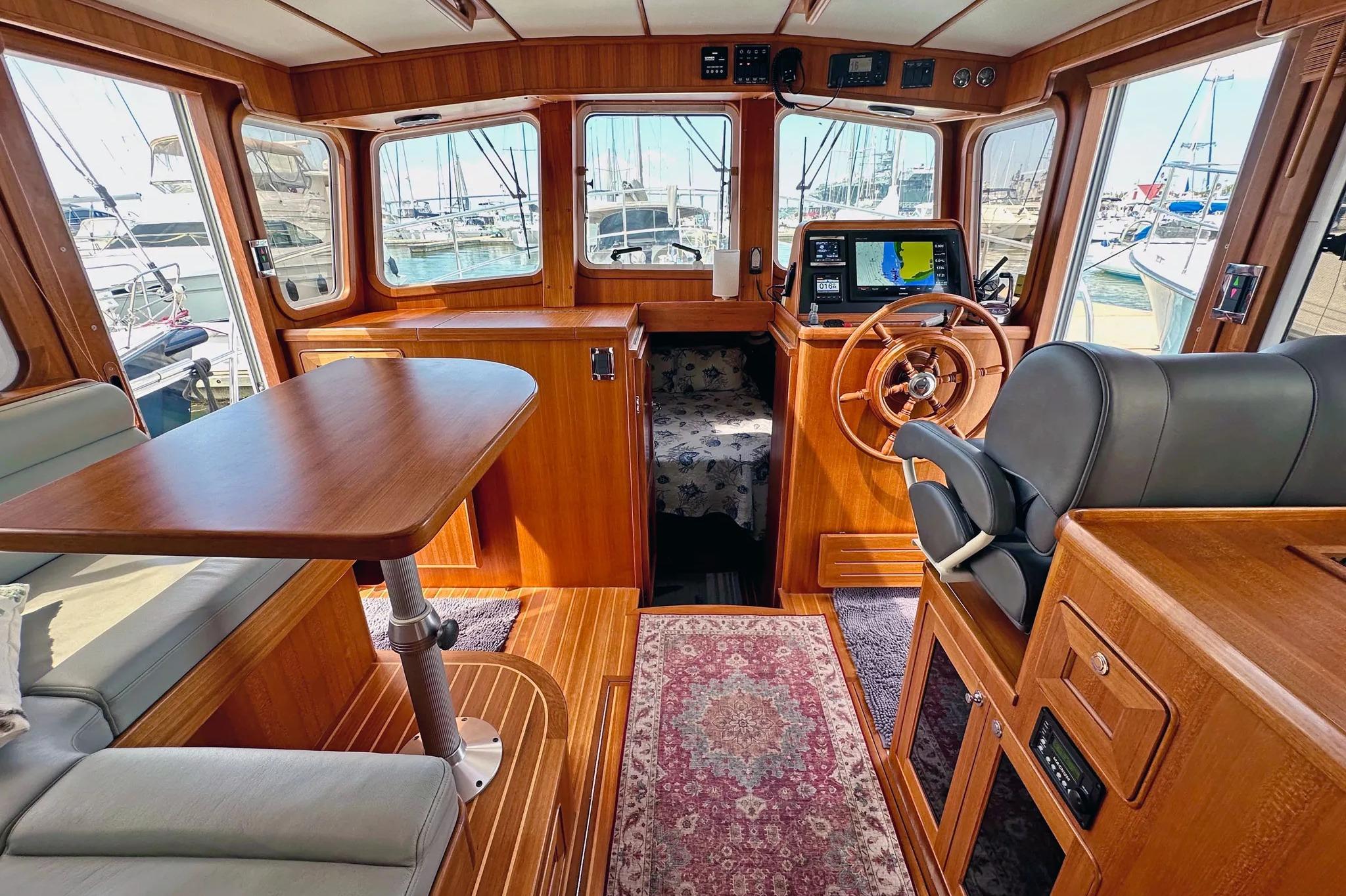 Interior of 2016 Helmsman Trawlers 38 Pilothouse with wood finish and navigation equipment.