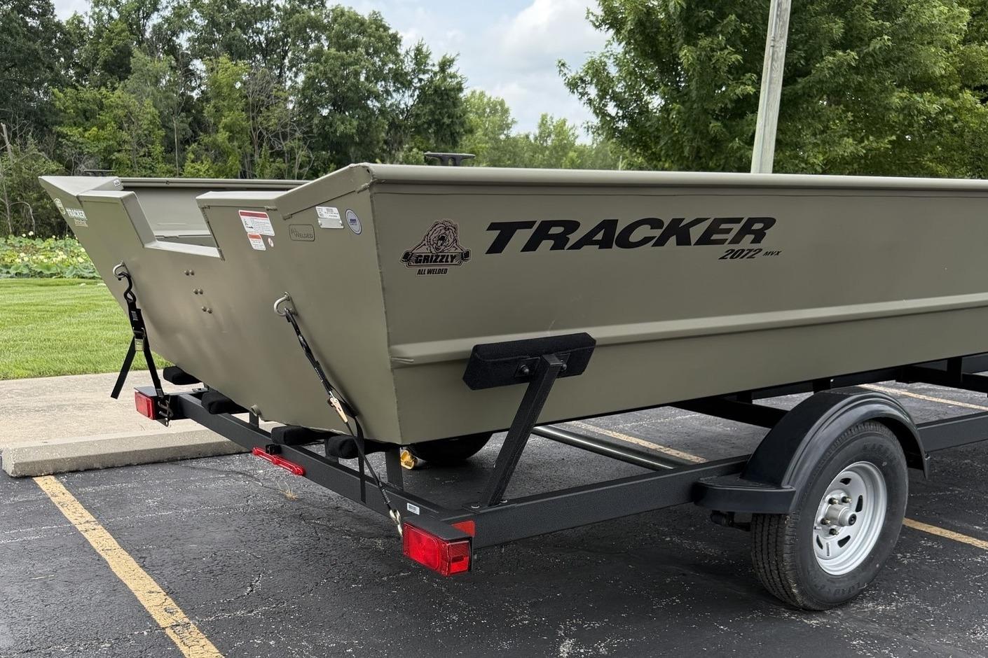 2025 Tracker Grizzly 2072 Utility boat on trailer in parking lot.