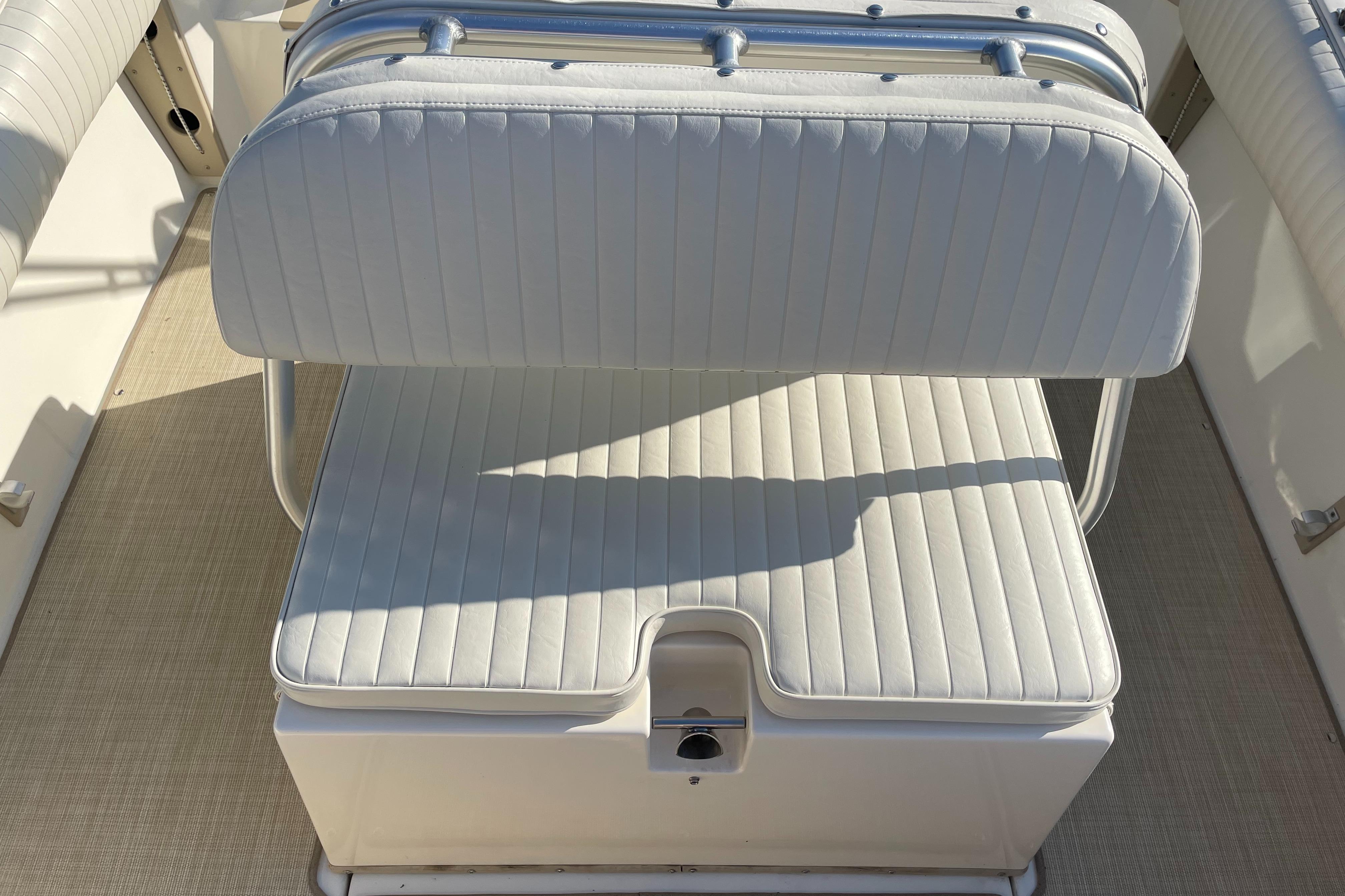 1998 Albemarle 247 Cuddy Express boat seat with white upholstery and storage compartment.