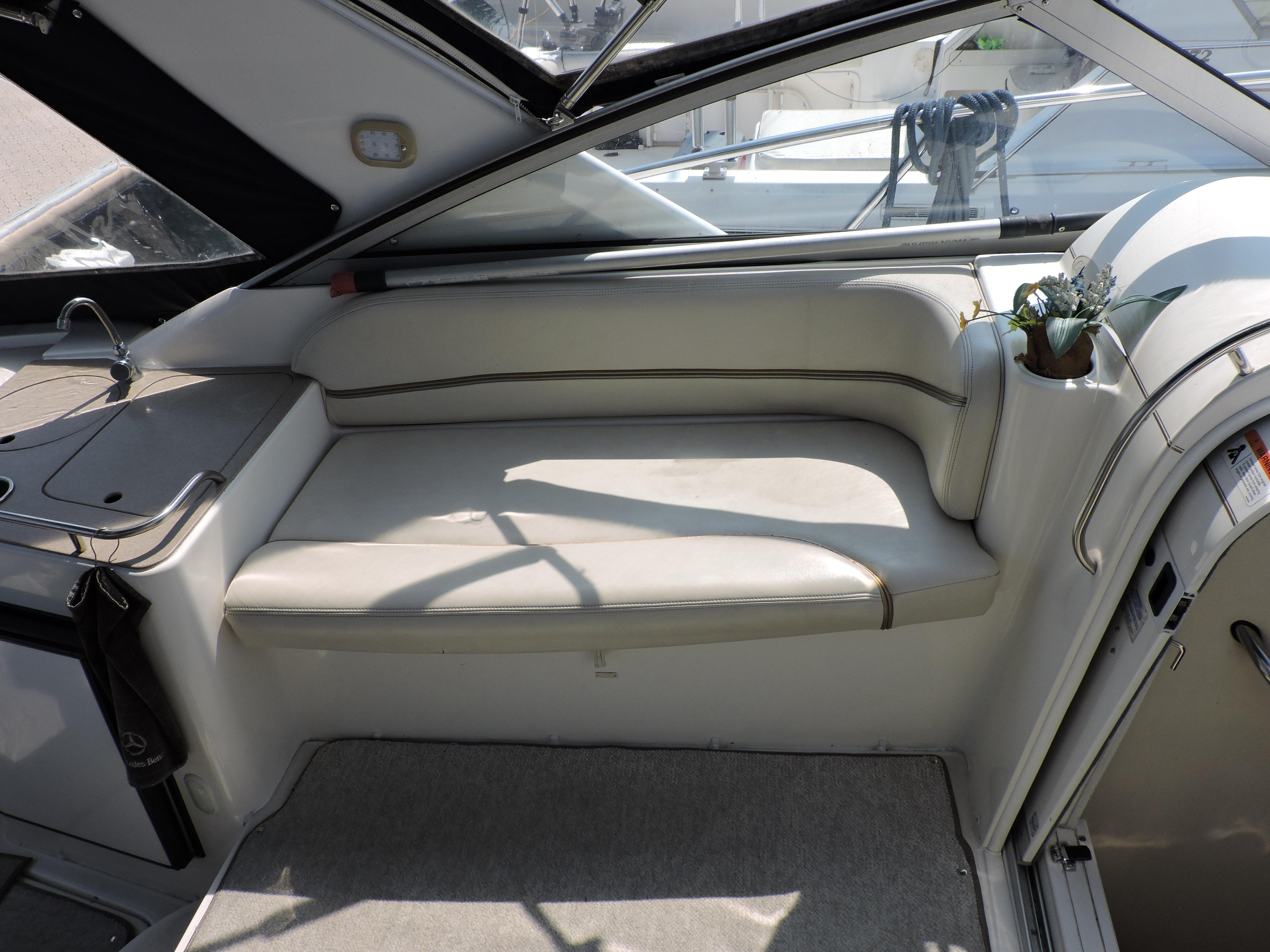 2005 Larson 330 Cabrio interior with beige seating and small potted plant.