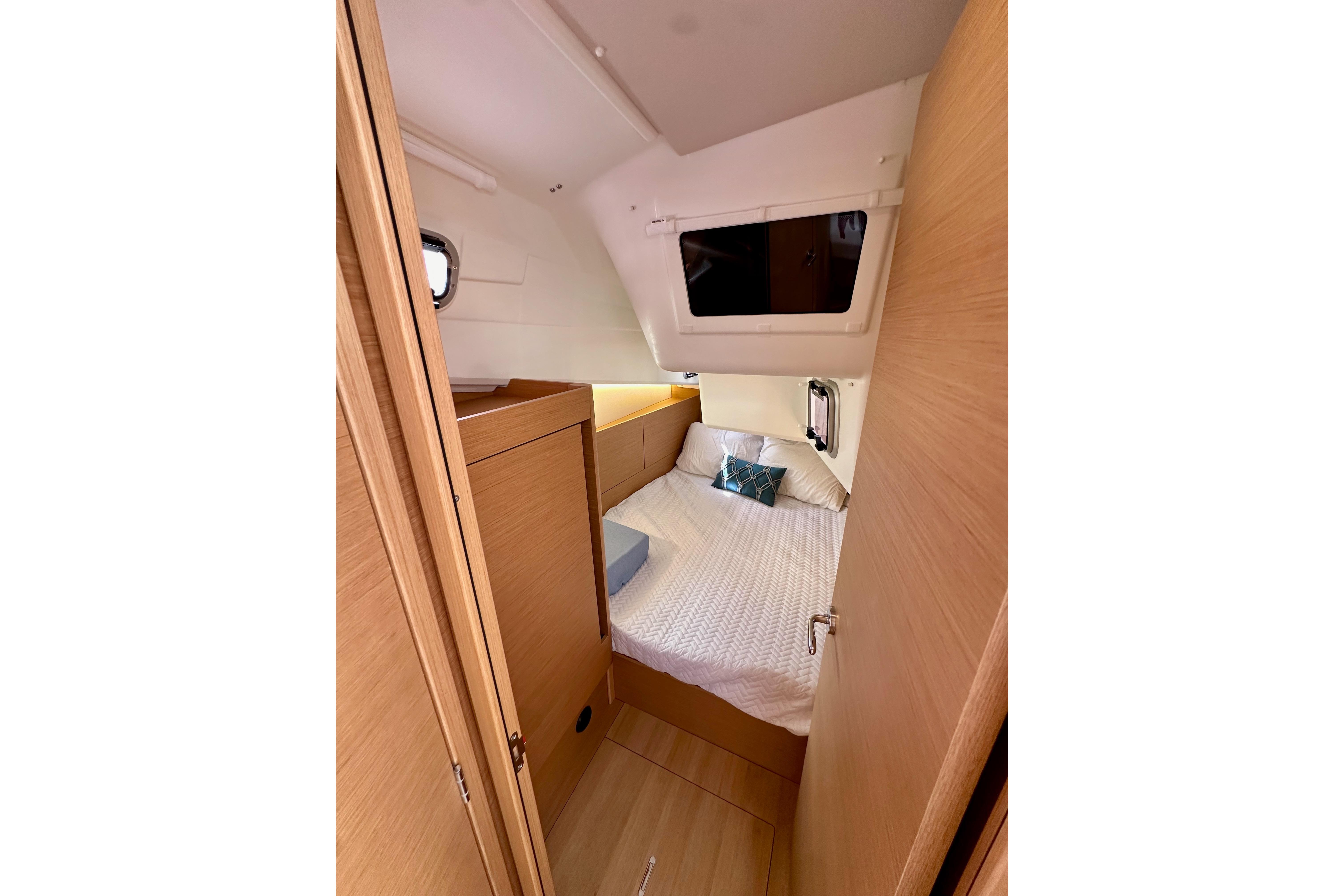 Cozy cabin interior of 2024 Jeanneau Sun Odyssey 410 sailboat, featuring a comfortable bed.
