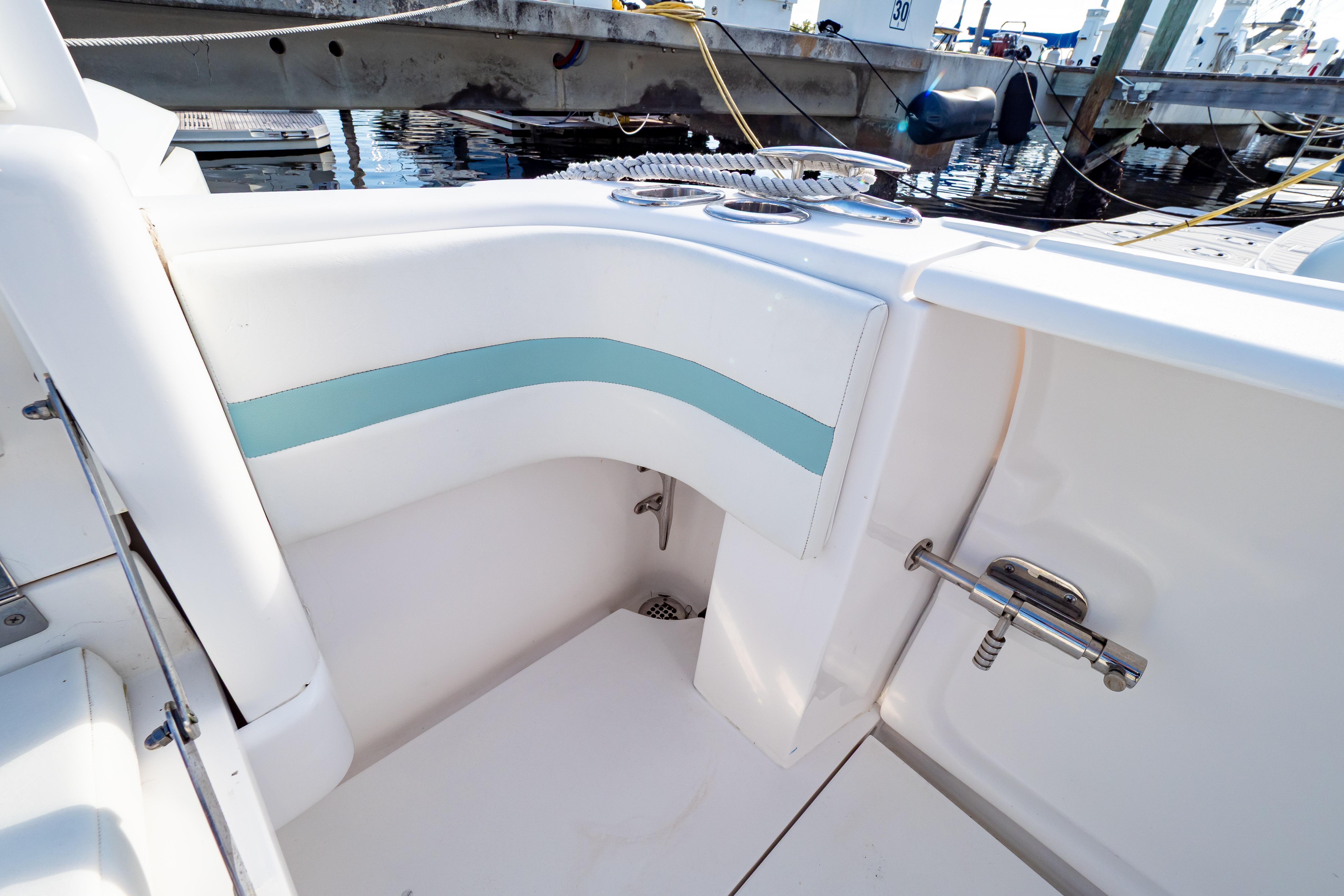 2018 Intrepid 475 Sport Yacht interior with white and teal seating, docked at marina.