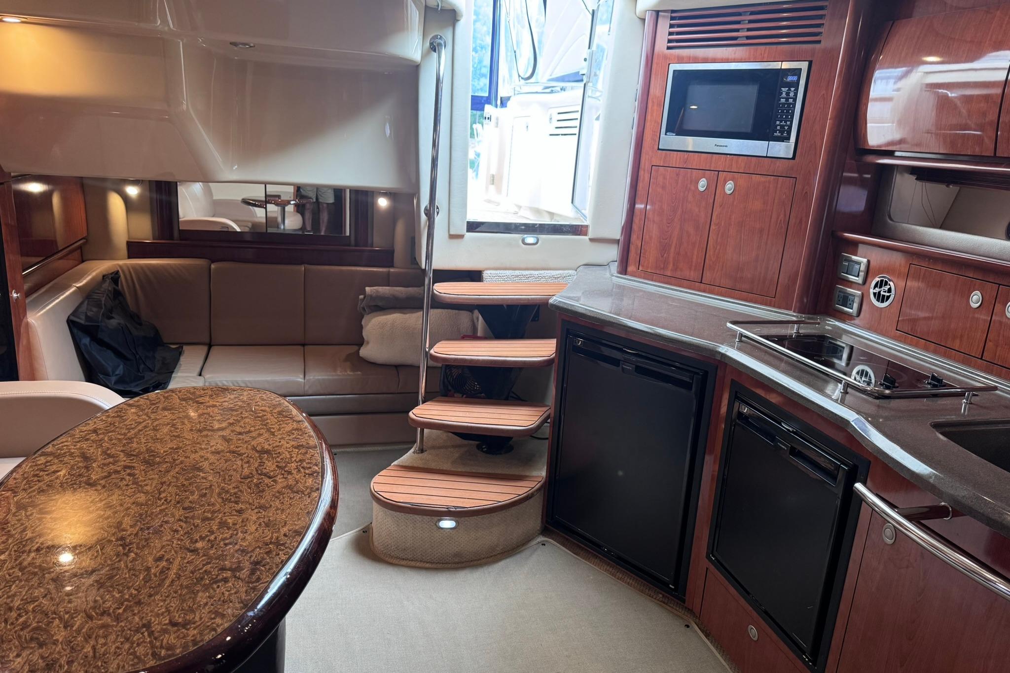 Luxurious interior of a 2004 Sea Ray 390 Sundancer yacht with kitchen and seating area.