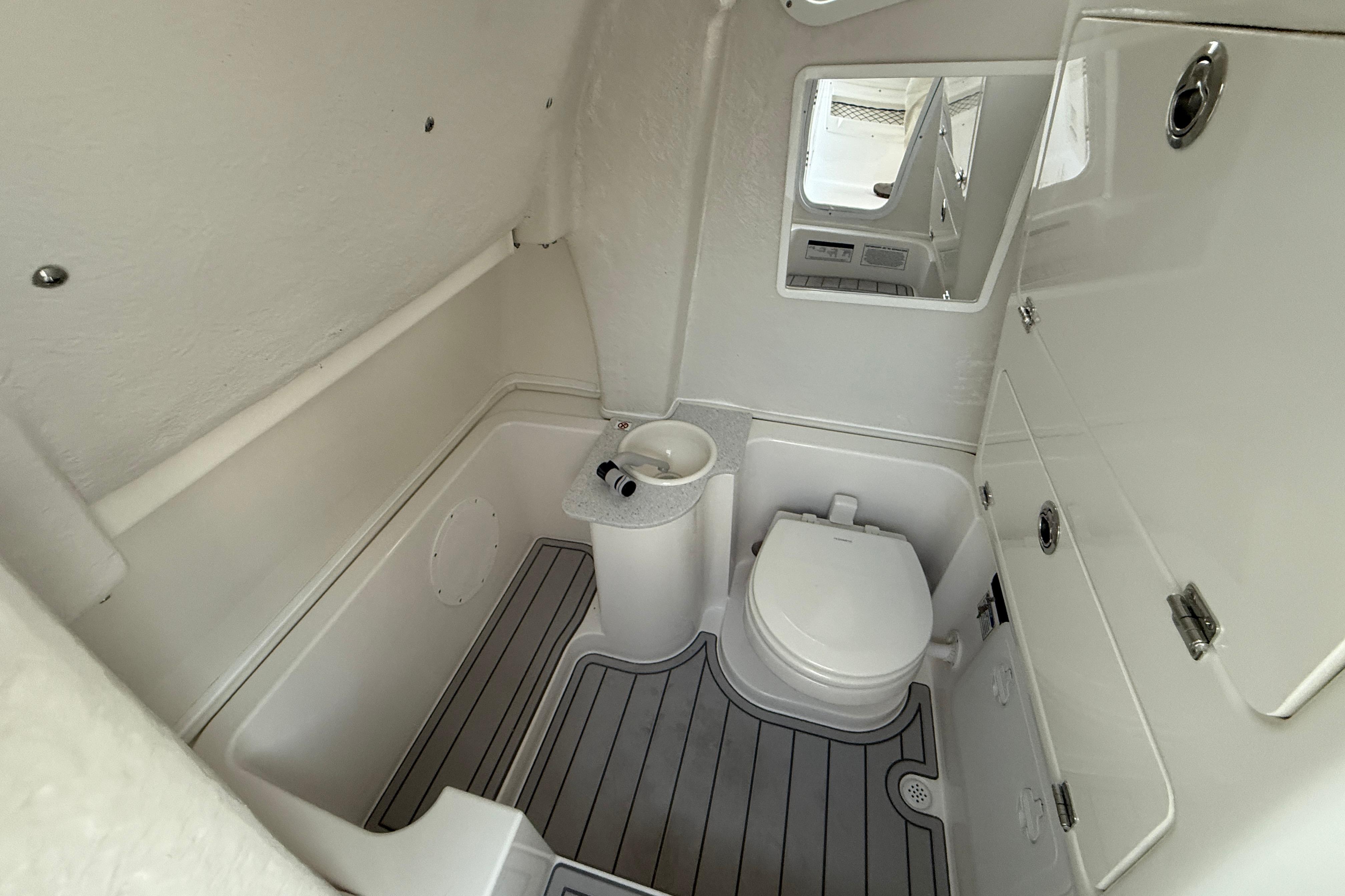 2026 Sea Fox 268 Commander boat bathroom with toilet, sink, and mirror.