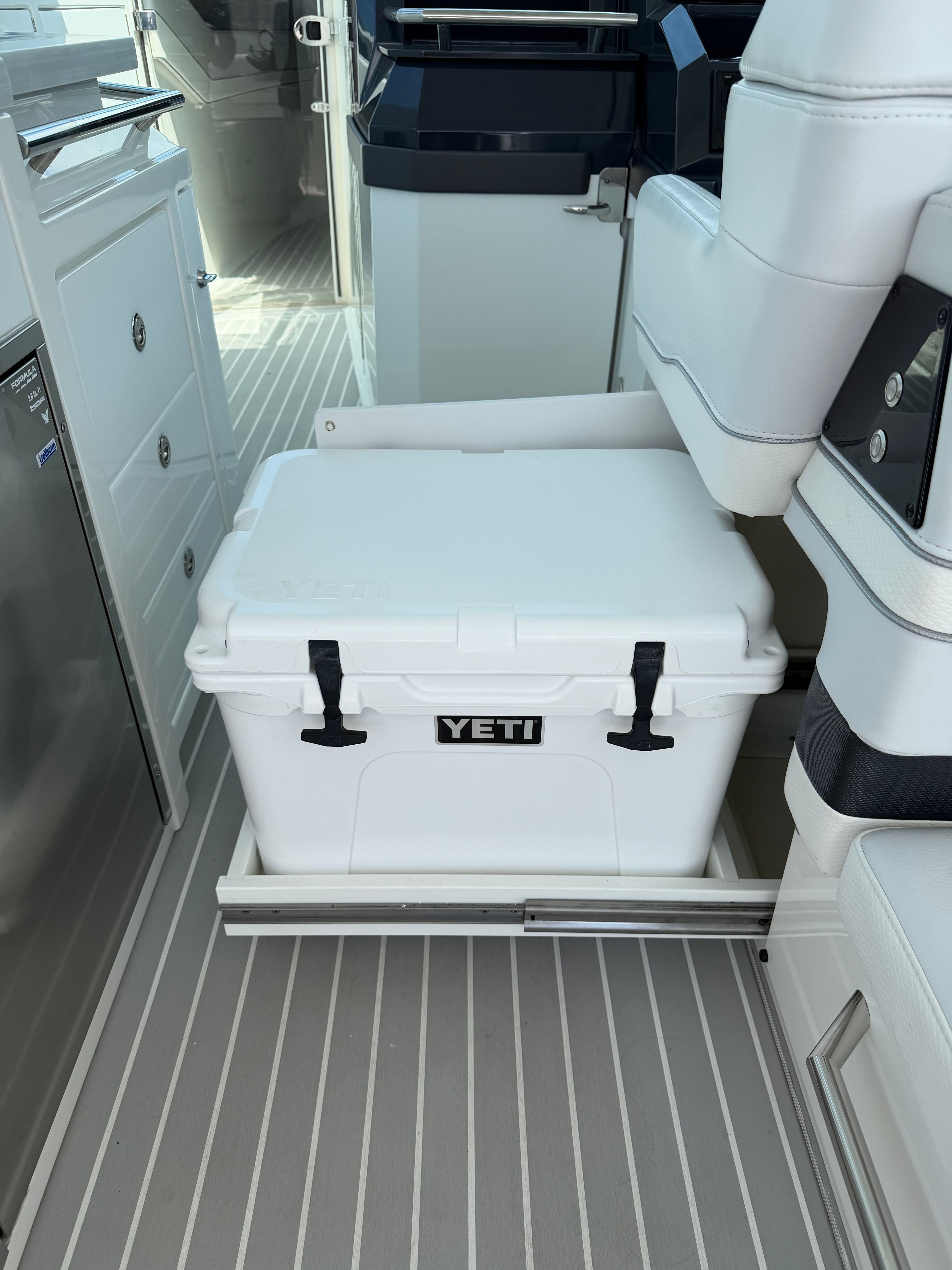 A white Yeti cooler on a pull-out tray in a modern boat.