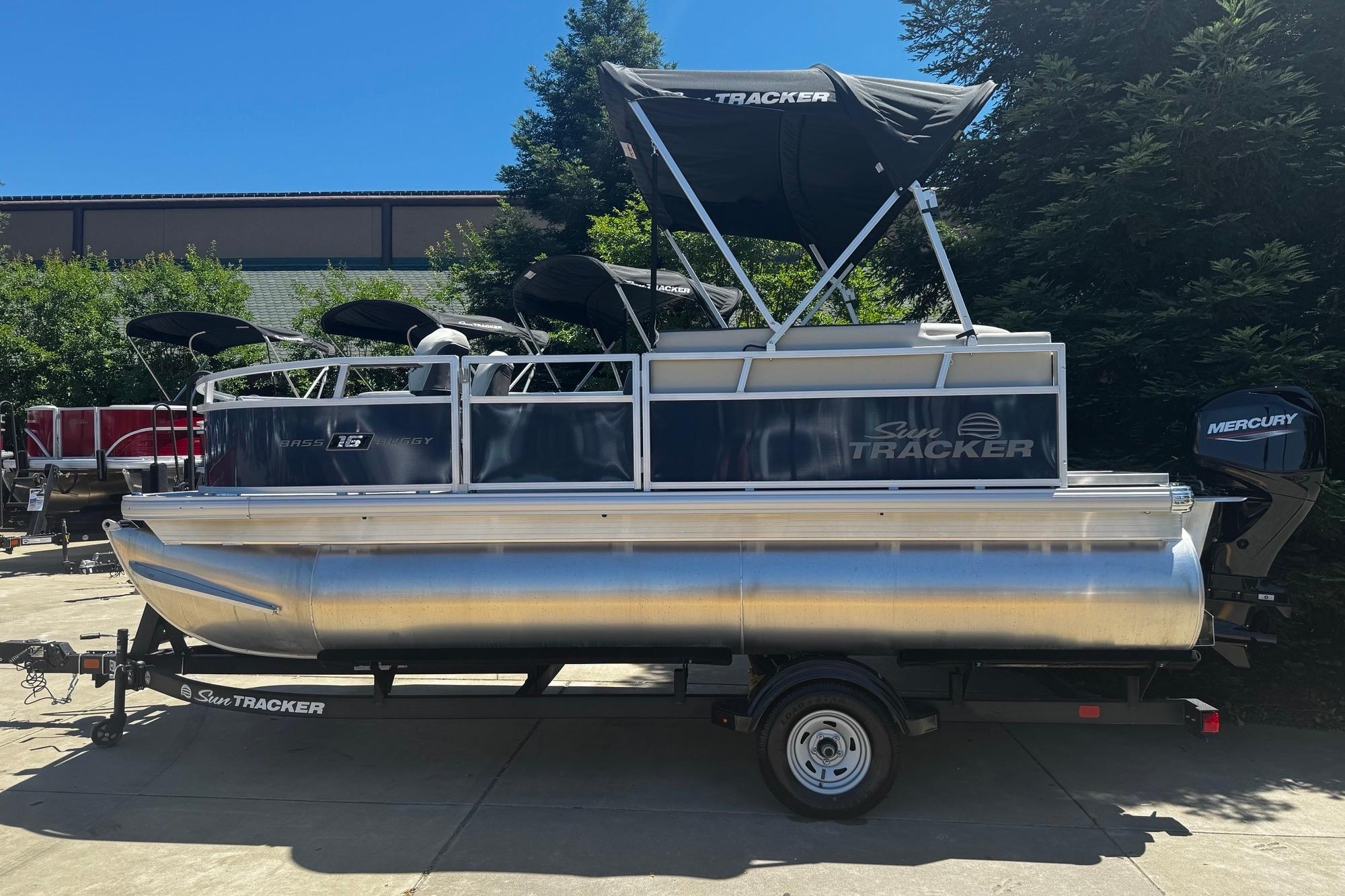 2026 Sun Tracker Bass Buggy 16 XL Select pontoon boat with Mercury engine on trailer.