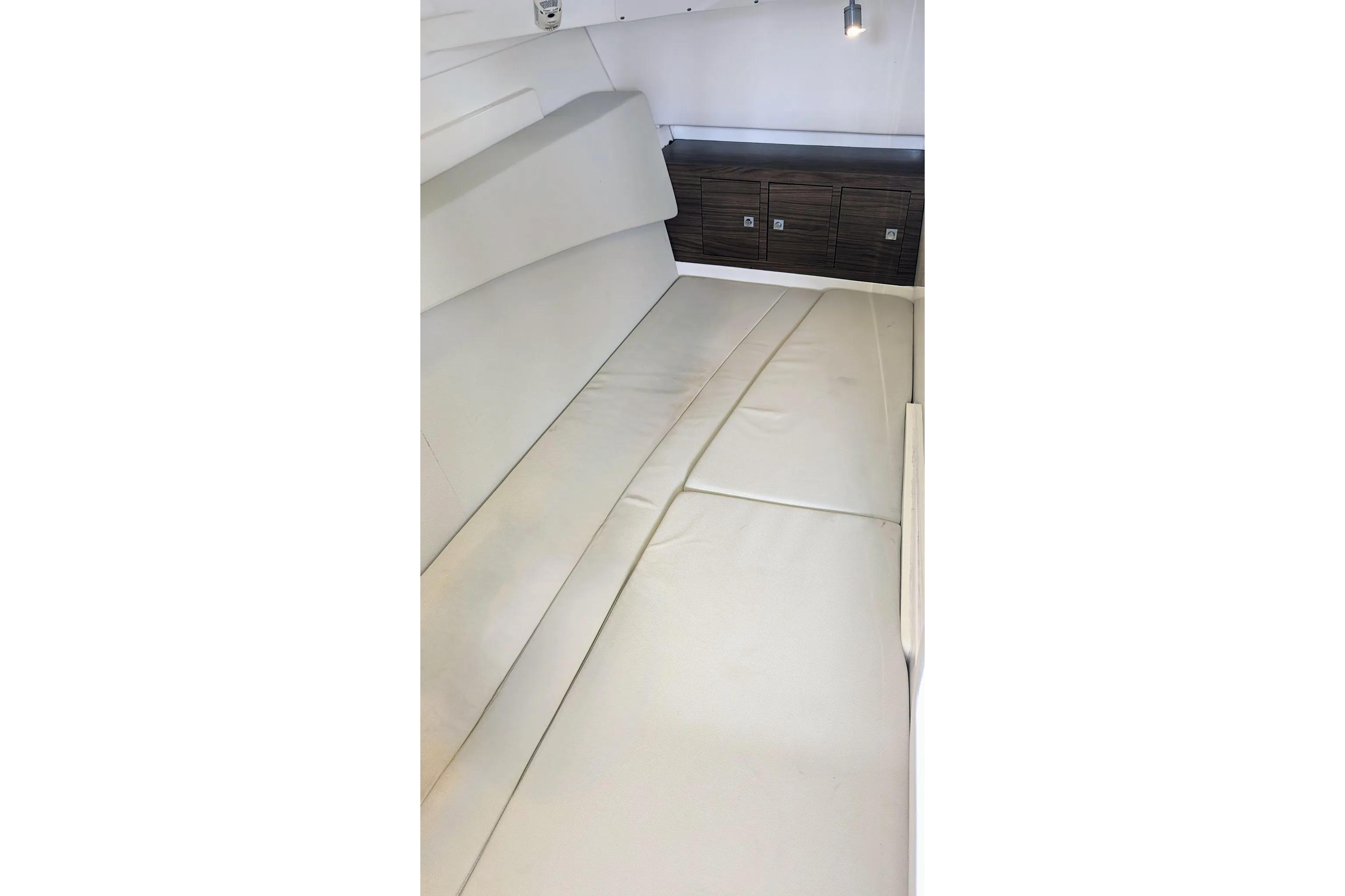 2017 Boston Whaler 320 Vantage interior cabin with cushioned seating and storage cabinets.