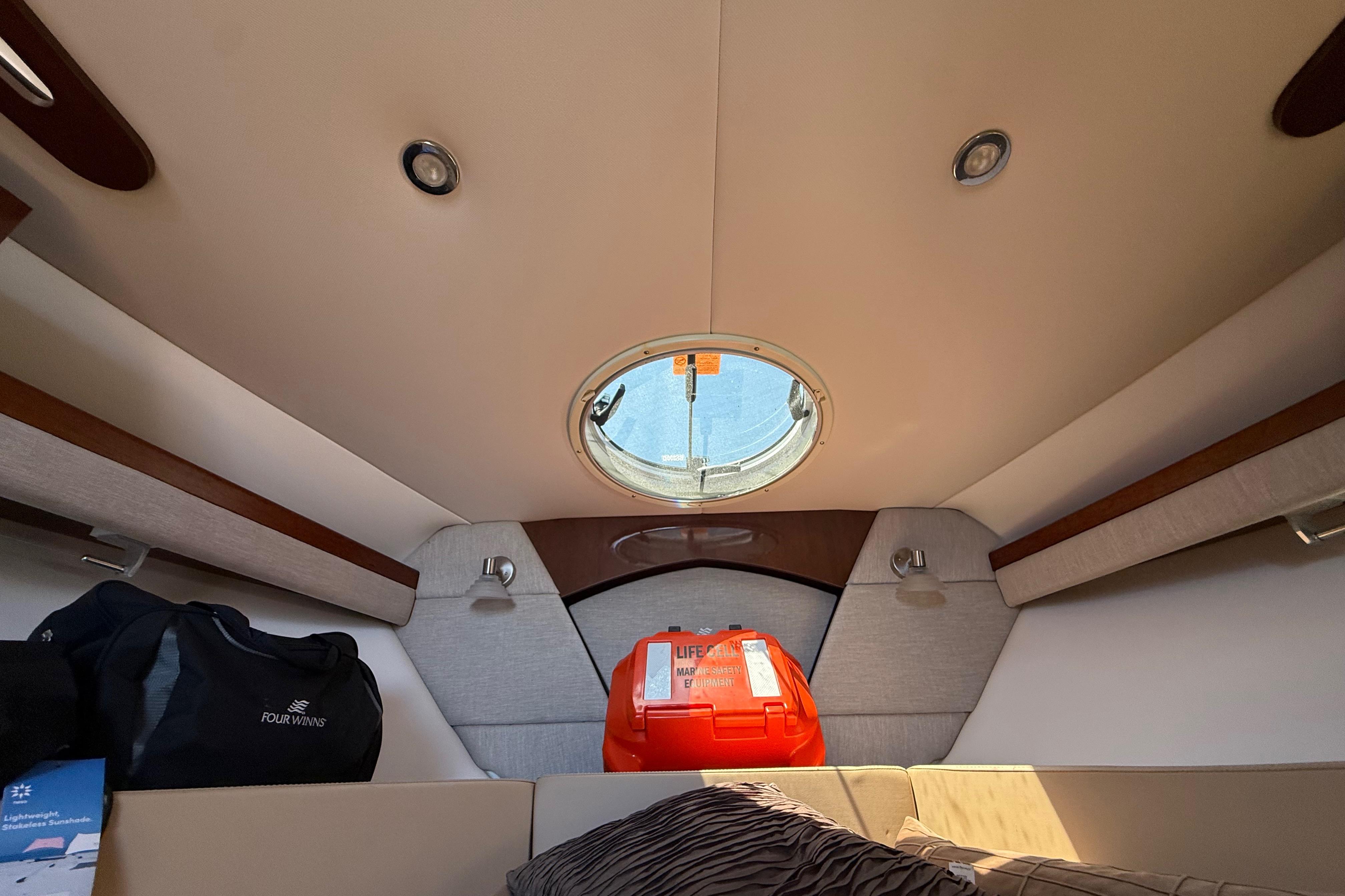 Interior cabin of 2017 Four Winns V275 boat with life jacket and porthole.