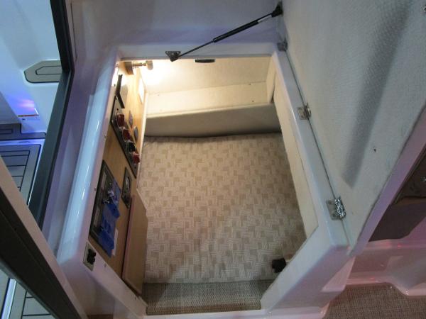 2025 Cutwater C-248 Coupe interior storage compartment with light and carpeted floor.