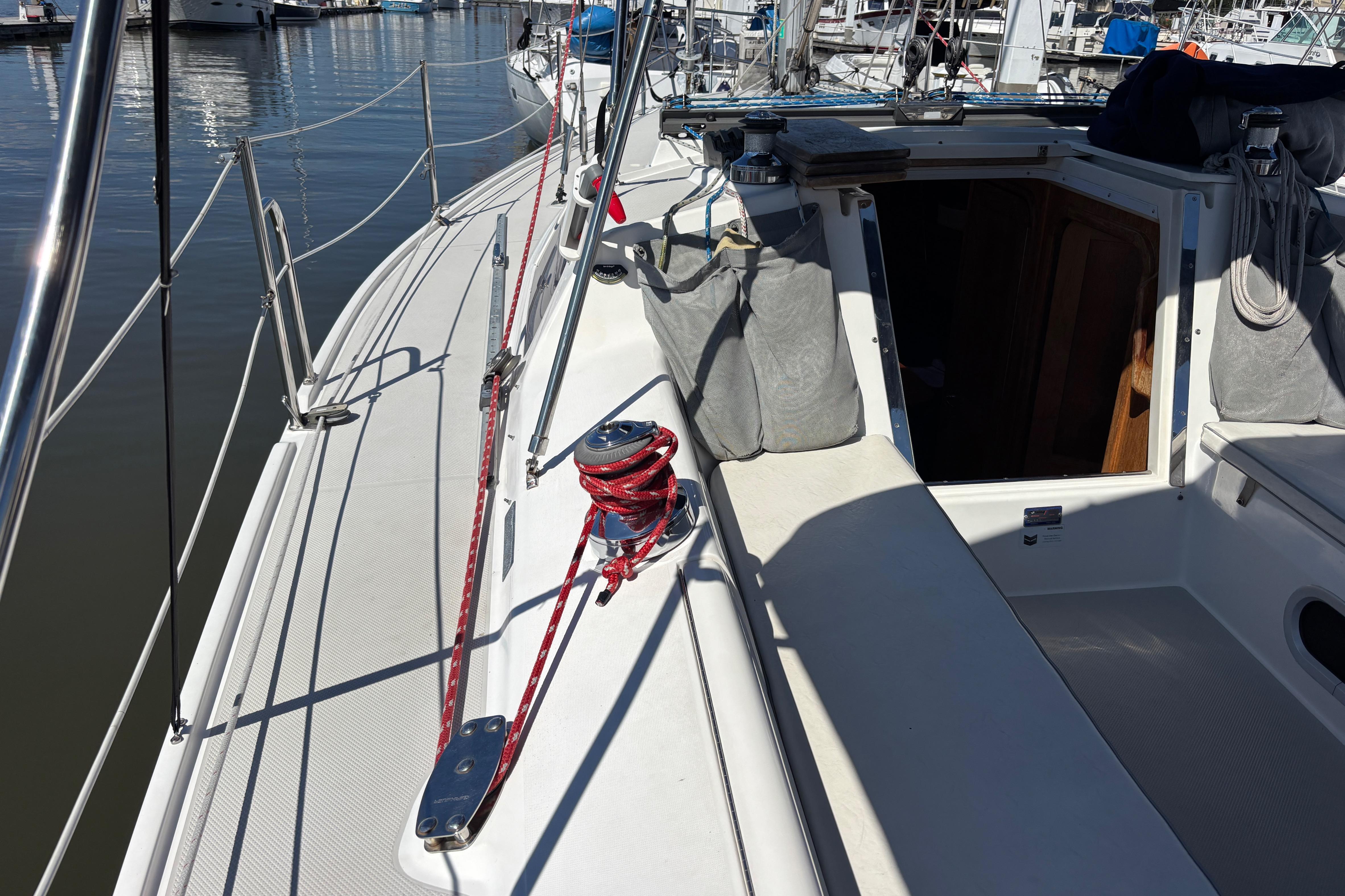 2006 Catalina 320 sailboat deck with winch and open cabin entrance.