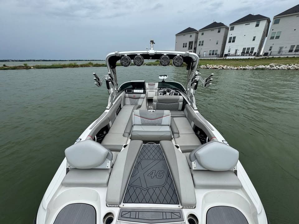 2015 MasterCraft X46 boat on calm water near houses.