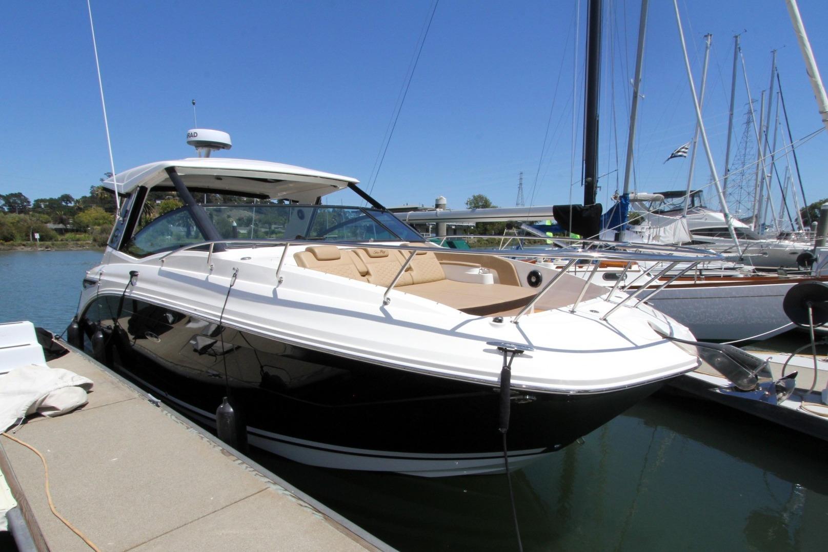 2021 Sea Ray Sundancer 320 Outboard docked at marina under clear blue sky.