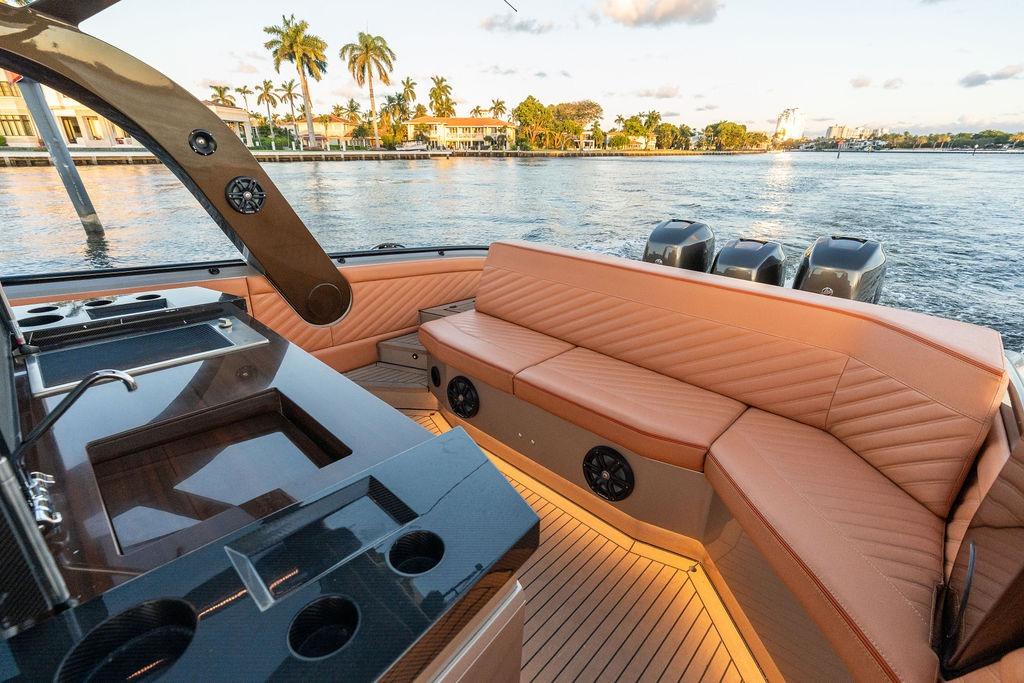 Luxurious 2023 DeKoning 43 yacht interior with leather seating and sleek design on a scenic waterway.
