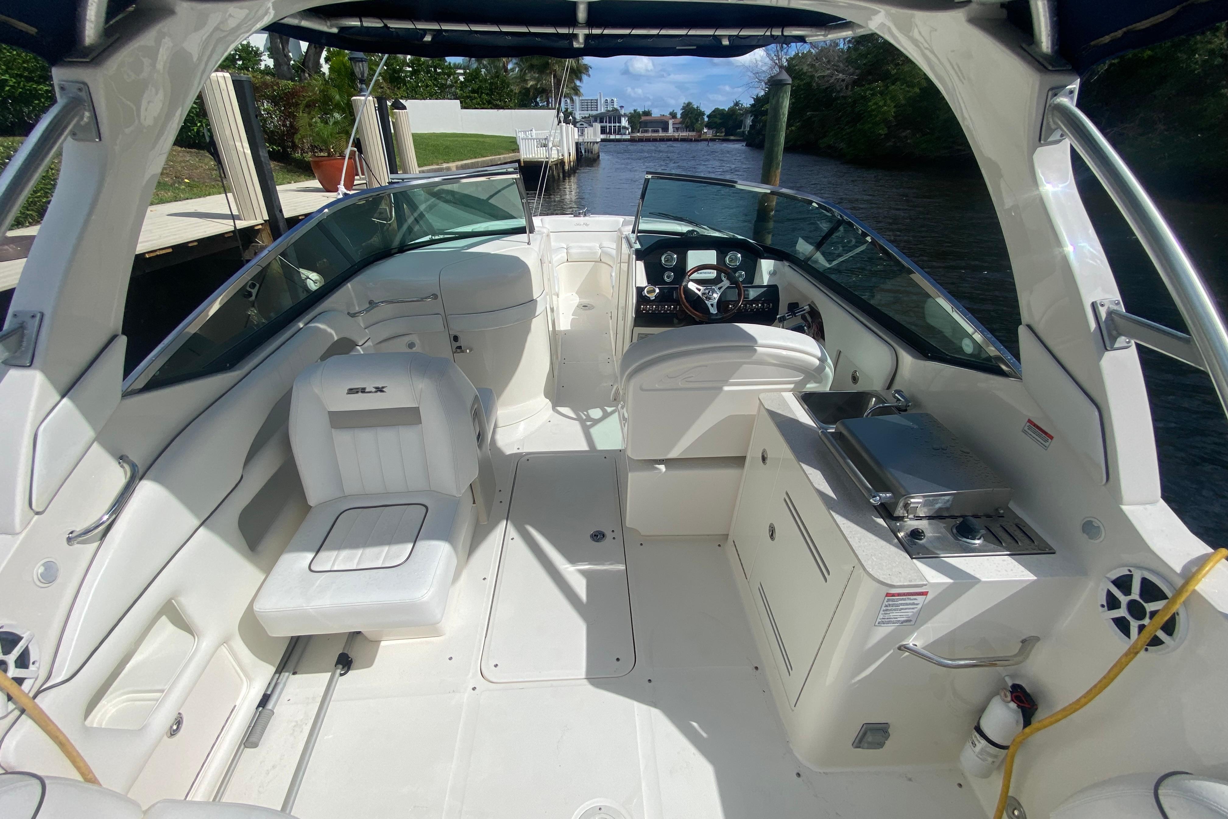 2010 Sea Ray 300 SLX boat interior with seating and helm, docked by a canal.