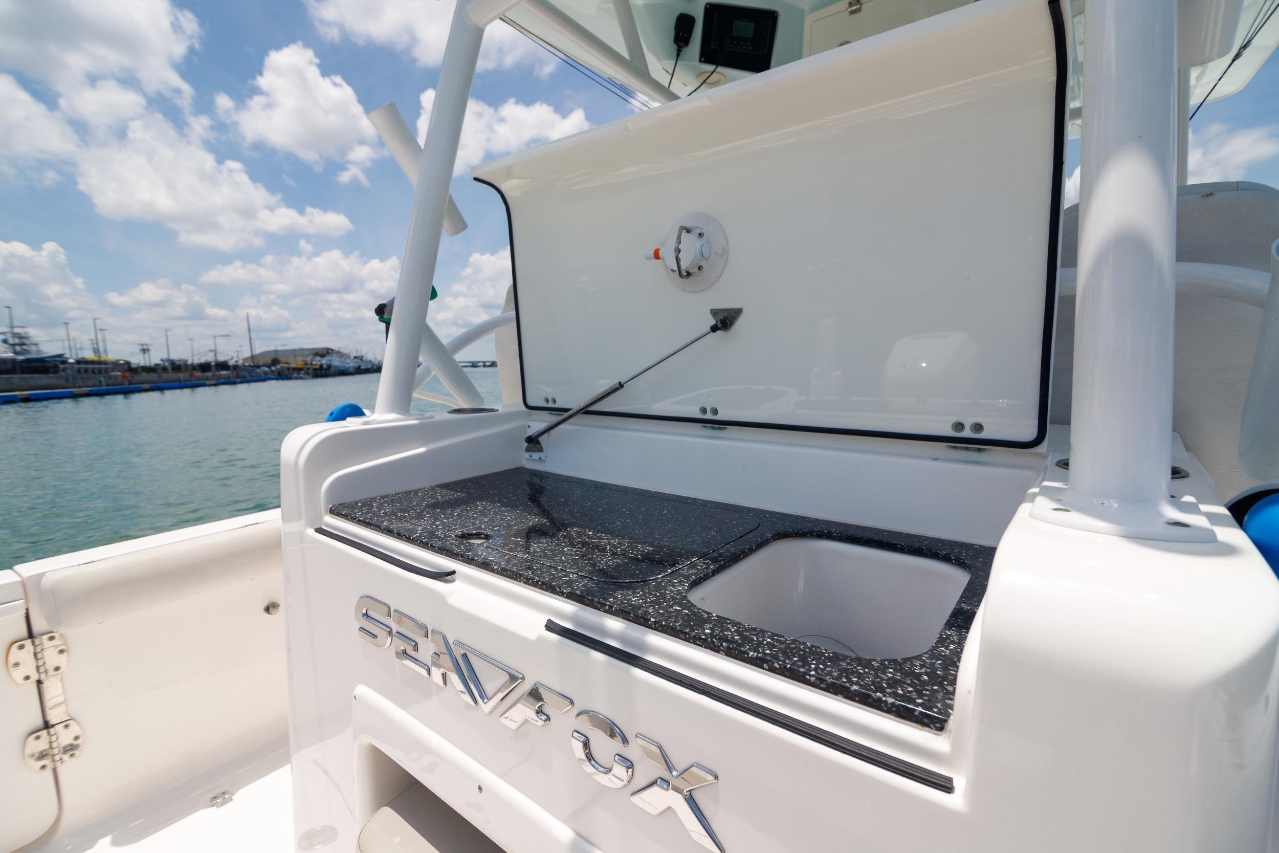 Sea Fox 328 Commander 2021 boat with open storage compartment and sink, docked by the water.