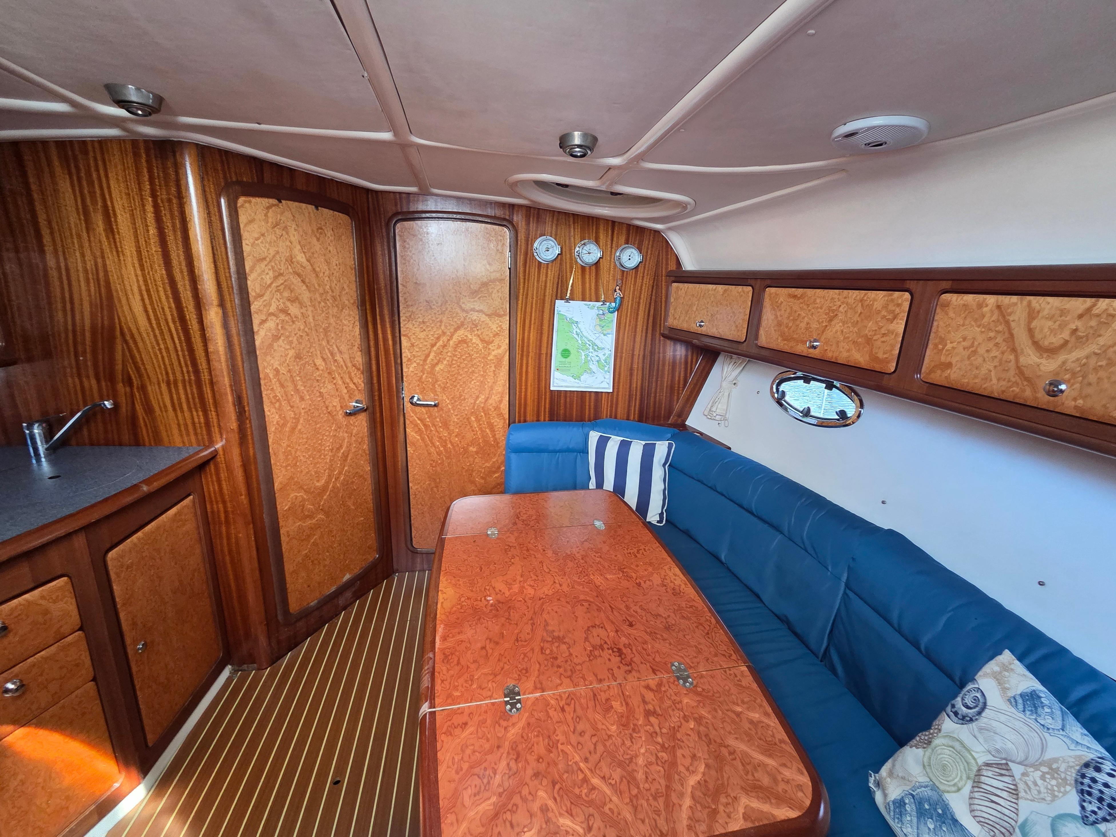 Interior of 2001 Bavaria 330 Sport yacht with wood finish and blue seating.