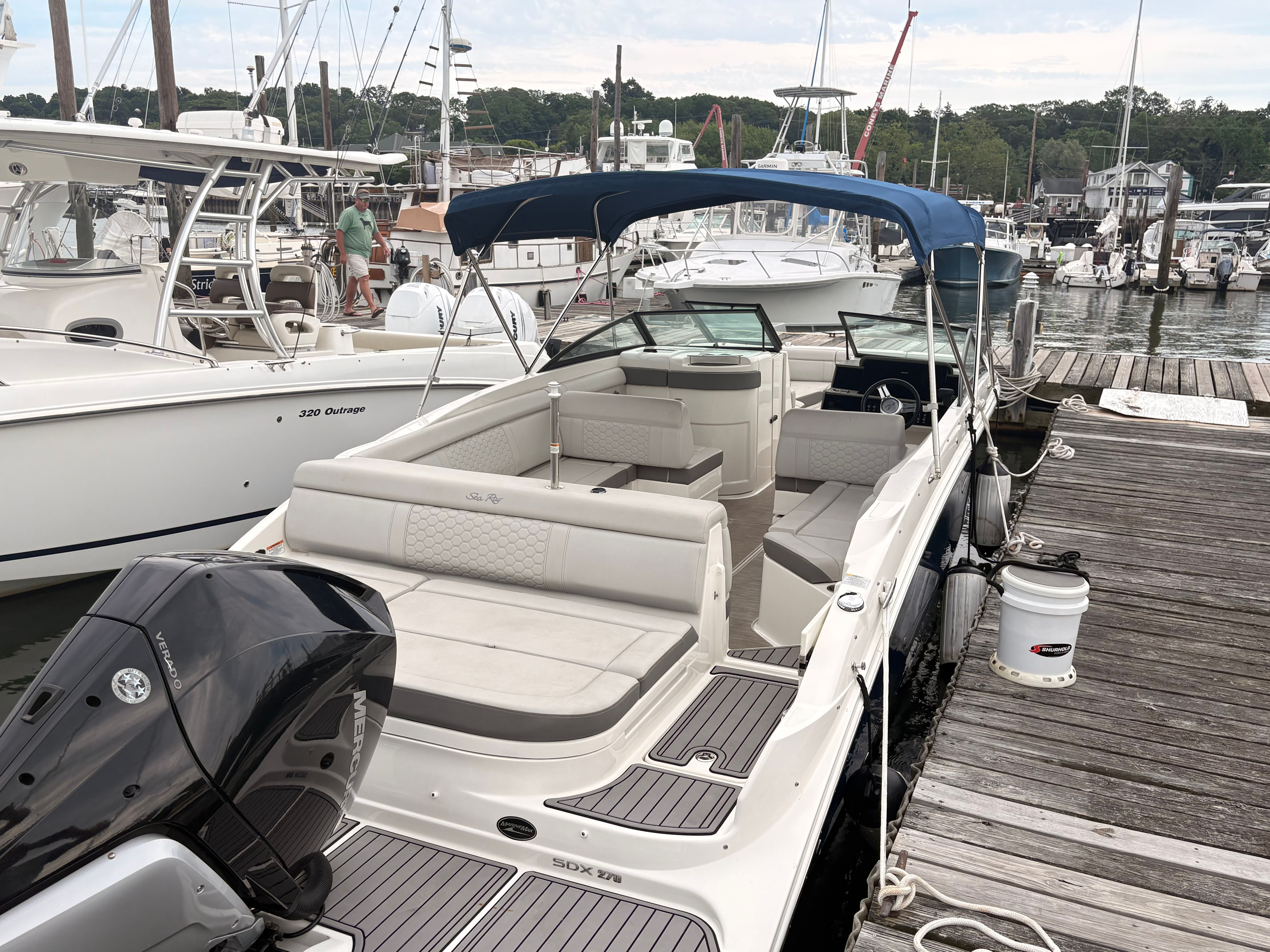 A 2022 Sea Ray SDX 270 Outboard is docked. It features a blue sunshade.