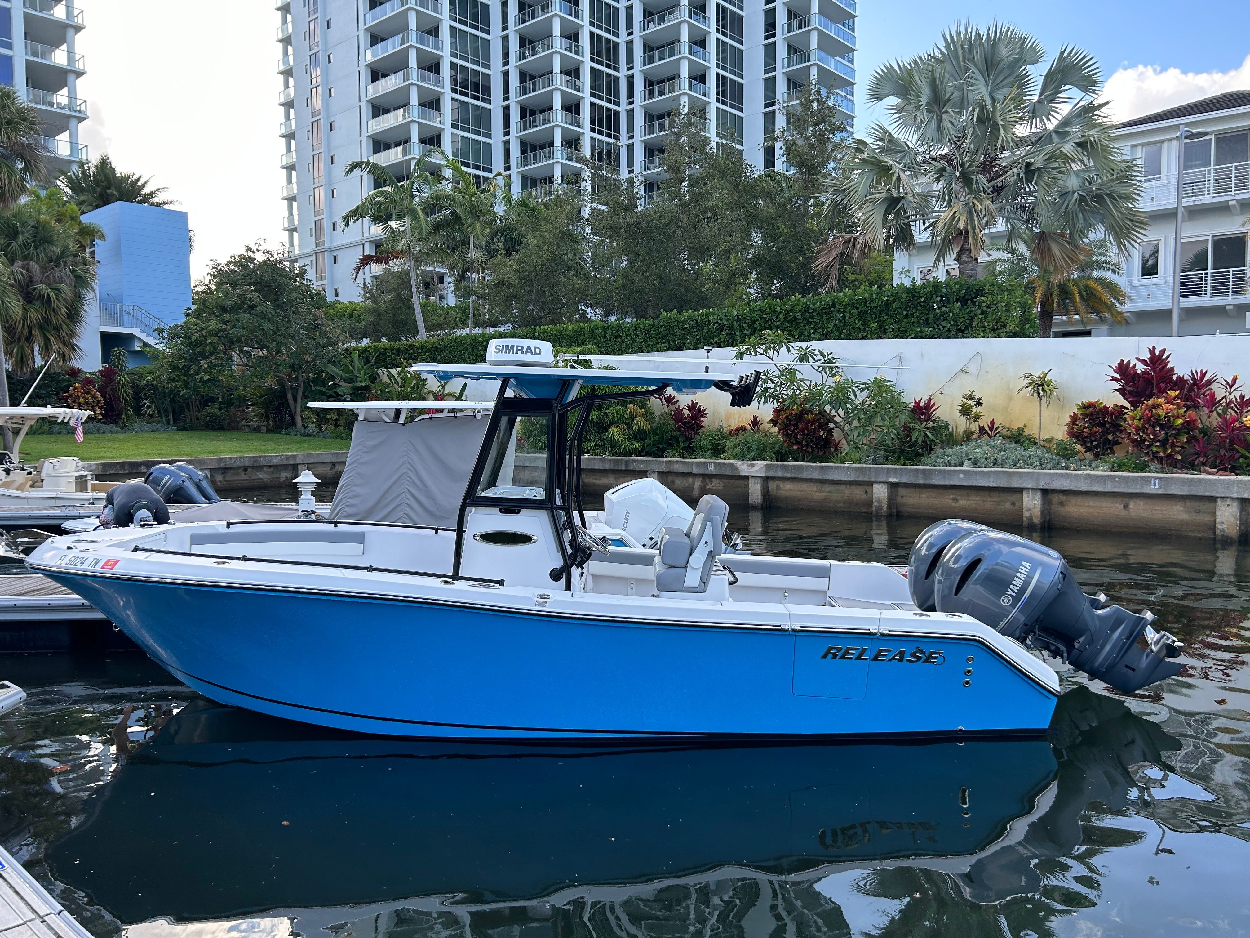 Blue 2022 Release 240 RX boat on water near high-rise buildings.