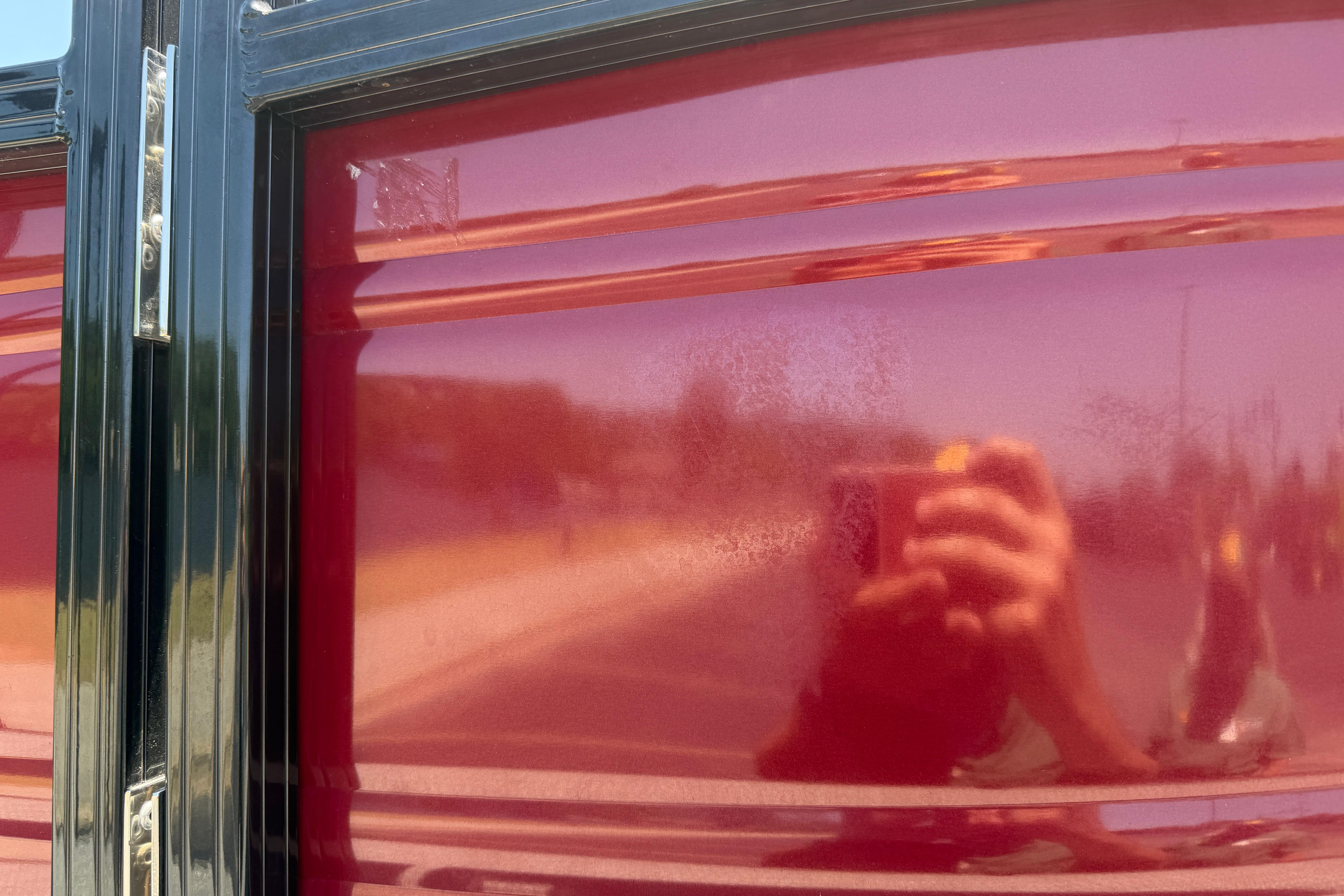 Reflection on glossy red surface of 2024 Regency R250DL3 vehicle.