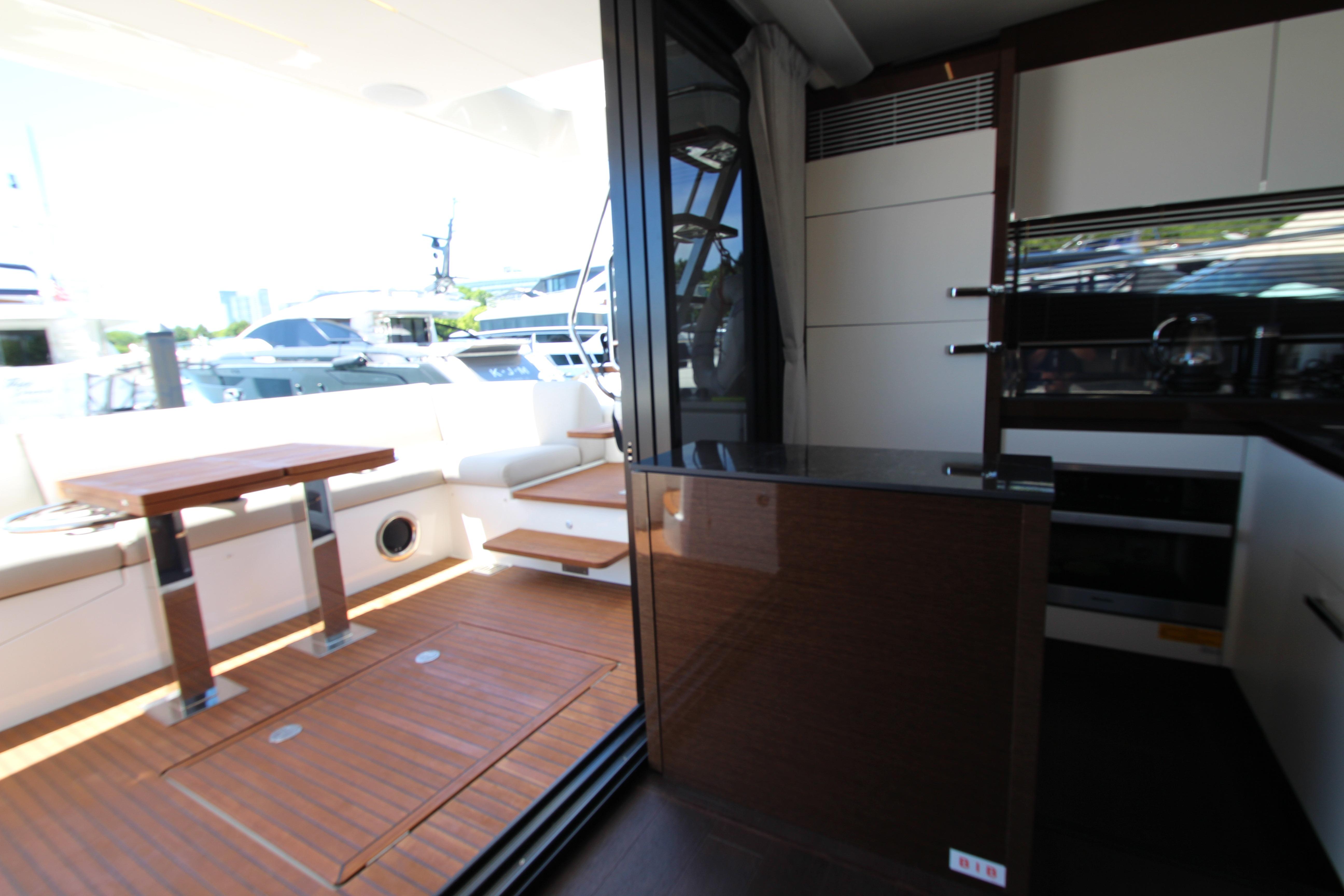 Luxurious interior of 2022 Prestige 520 yacht with modern seating and dining area.