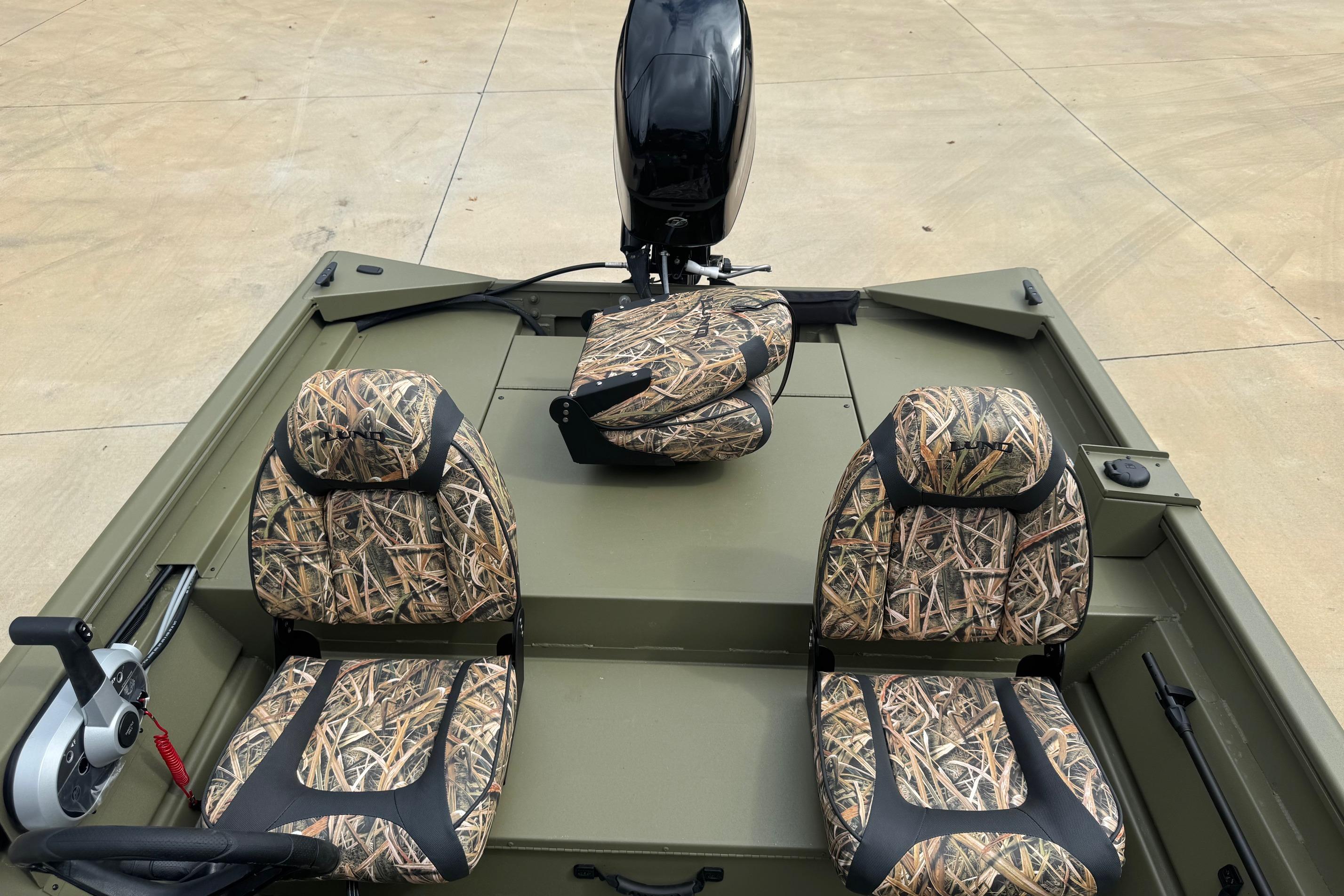2026 Lund 1760 Predator SC boat with camouflage seats and motor, on concrete surface.