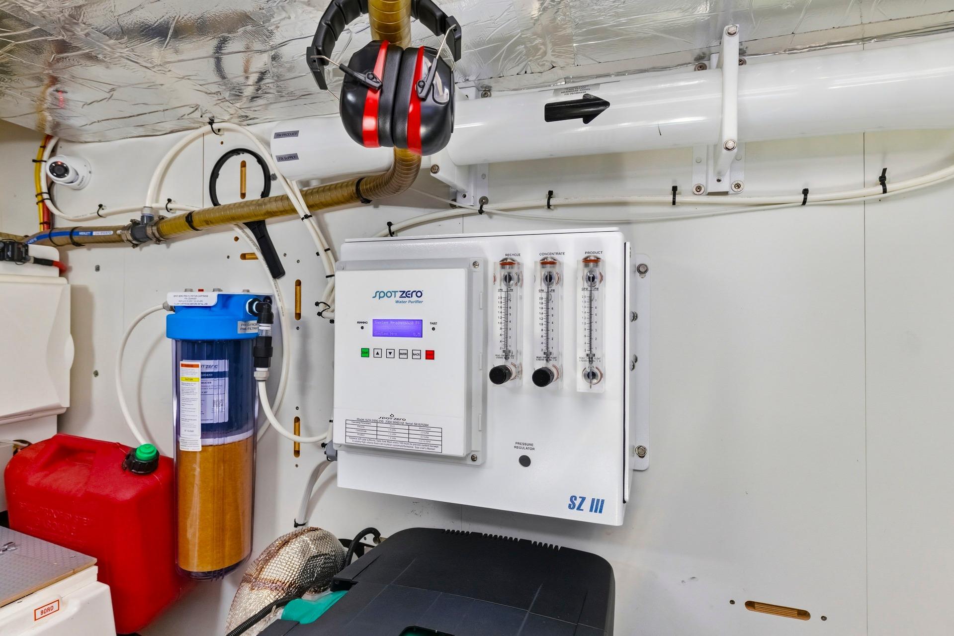 Engine room of 2022 Prestige 520 yacht with water purifier system and safety equipment.