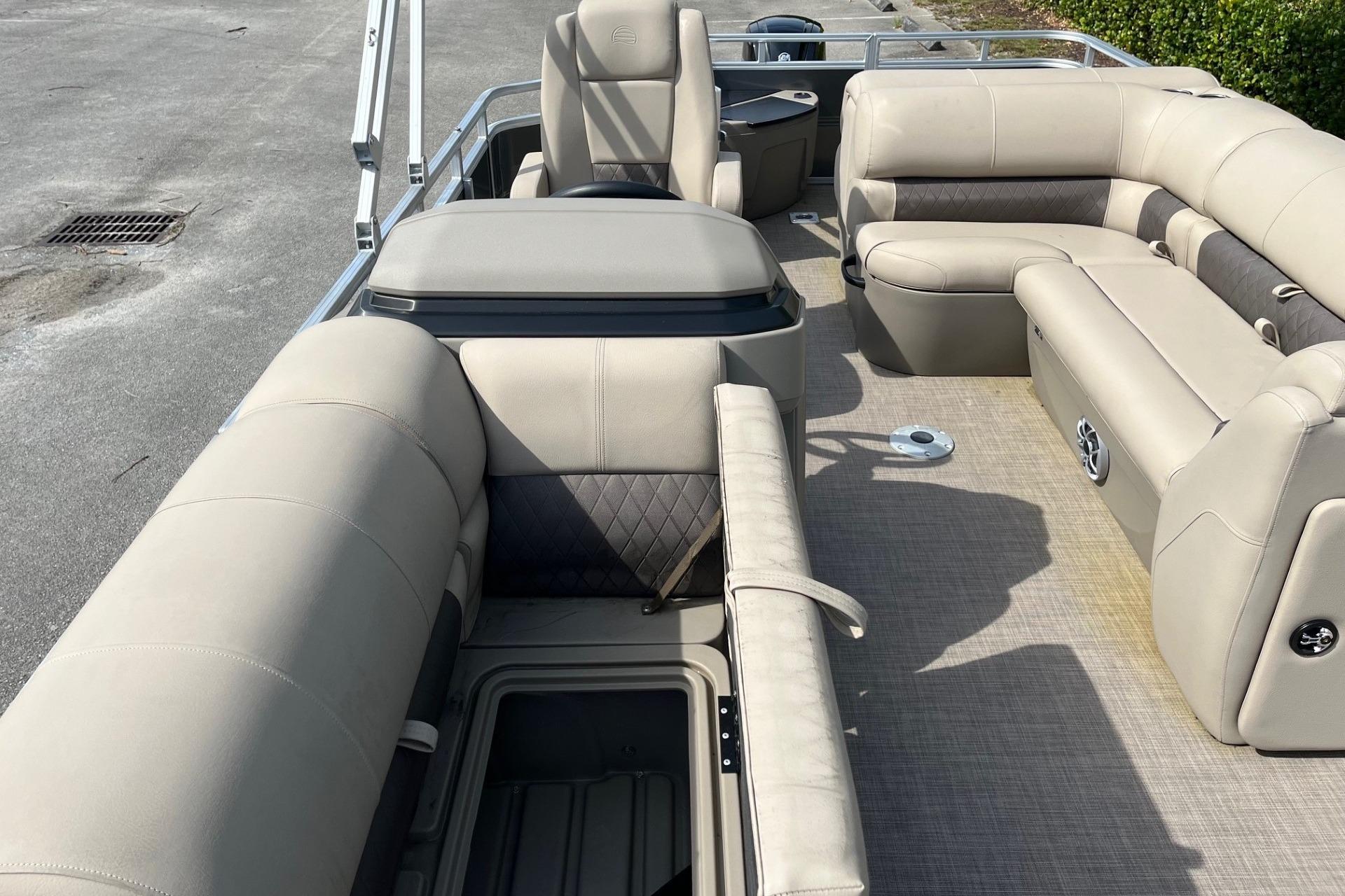 2025 Sun Tracker Fishin' Barge 20 DLX interior with beige seating and storage compartments.