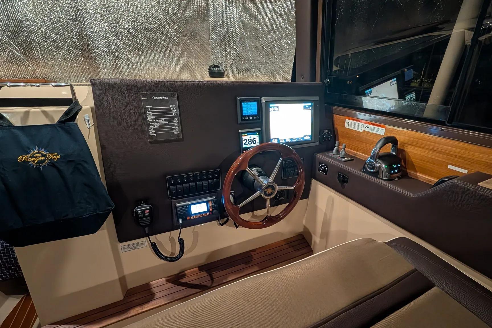 Helm of 2015 Ranger Tugs R-29 S with steering wheel and navigation displays.
