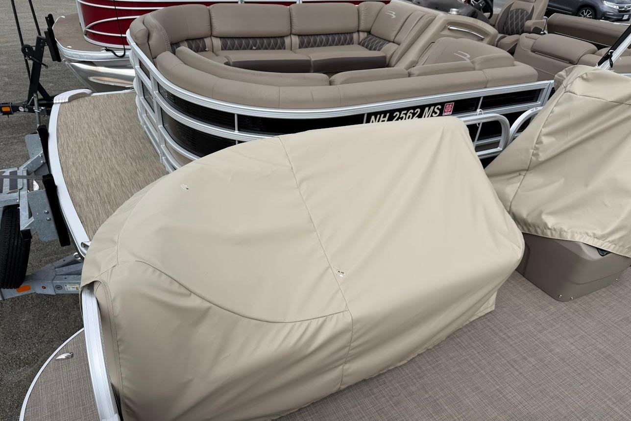 2025 Sun Tracker Party Barge 16 DLX with beige seating and protective covers.