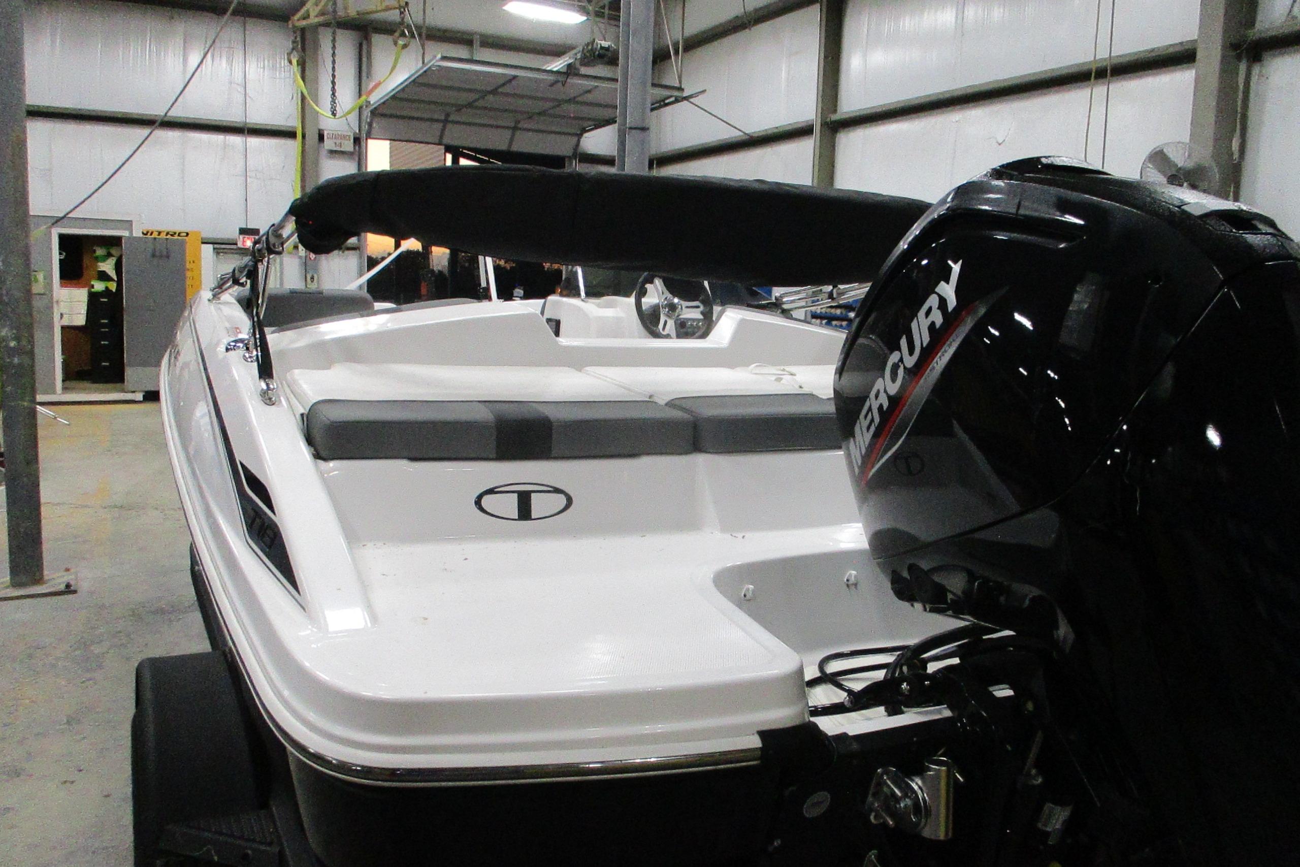 2025 Tahoe T18 boat with Mercury engine in a warehouse setting.